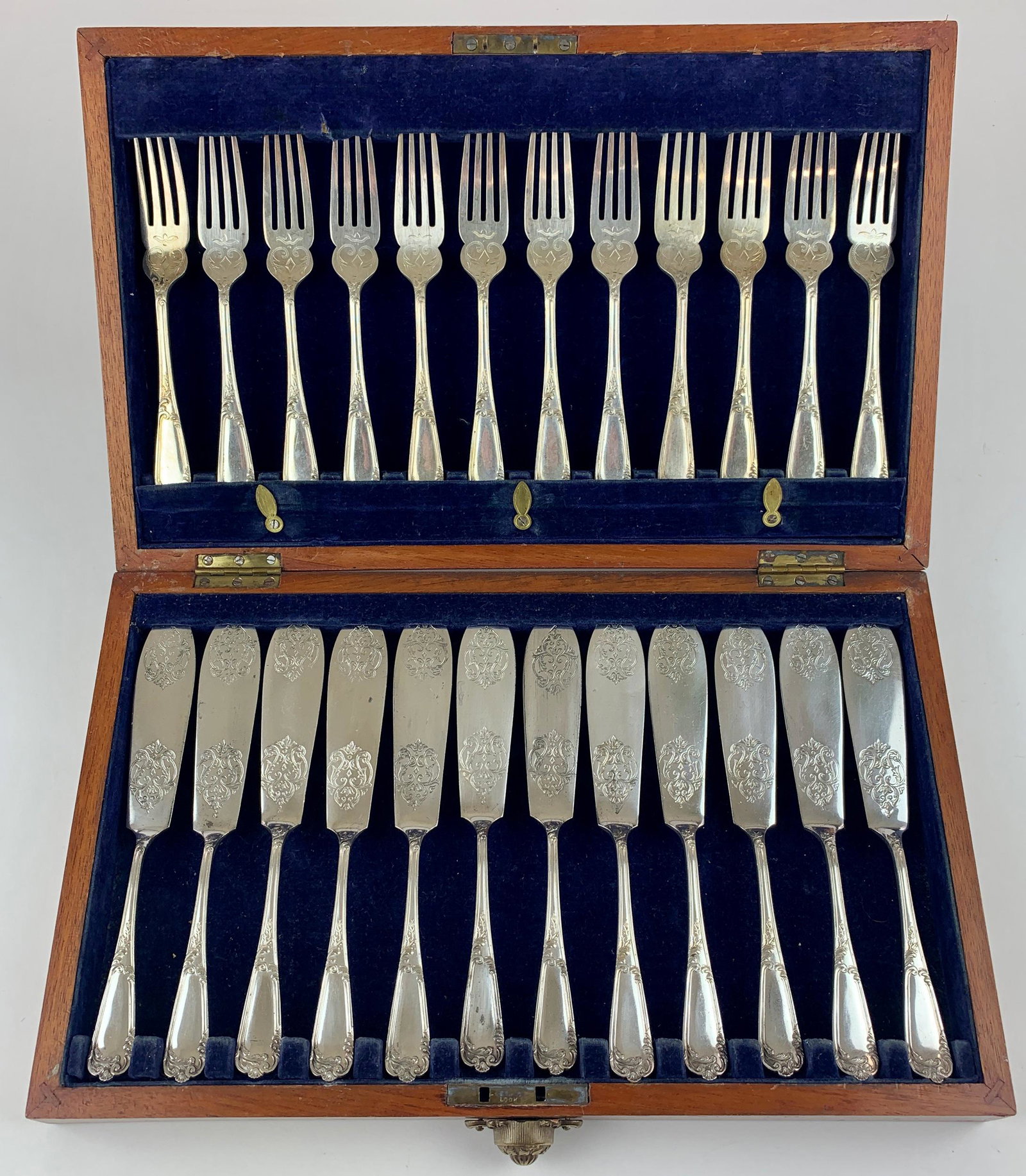 Bradbury Silver Plated Boxed Flatware: An incised and elaborate boxed set of knives and forks for 12, each hallmarked. Box measures 8.75" x 14.25".