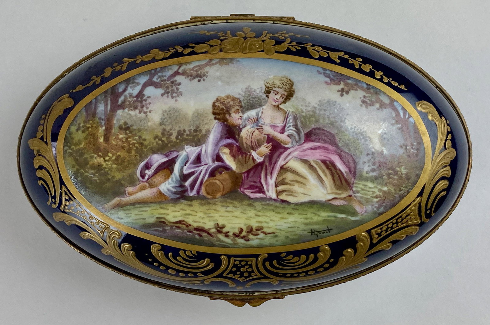 19th Century Sevres Hand Painted Box, Signed: A porcelain decorated box, with central reserve depicting pair of courting figures, gilt decoration, signed to the scene and marked to underside; lg. 8". From the Estate of Harold and Miriam Prigozen,