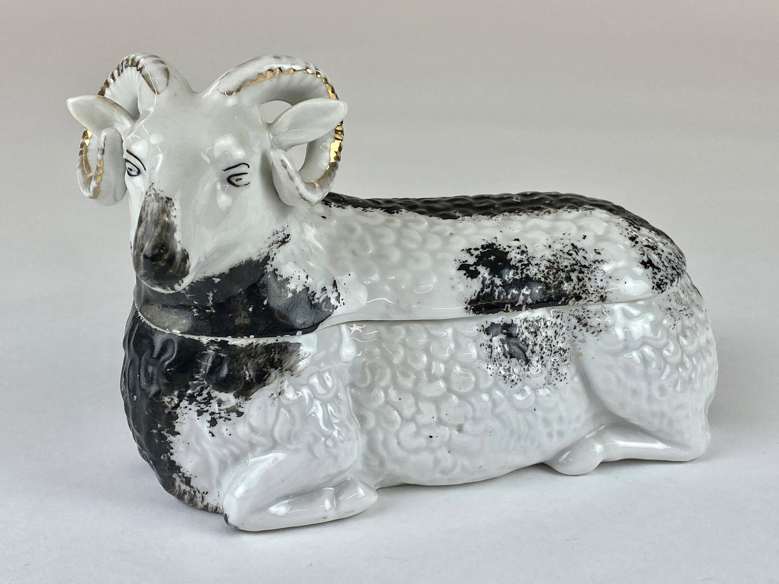 A Russian Kuznetsov Porcelain Ram Form Box: Porcelain, 19th century, with blue mark to underside and two-piece covered and painted box. lg. 6.75", ht. 5" From the Estate of Harold and Miriam Prigozen, Dayton, OH.