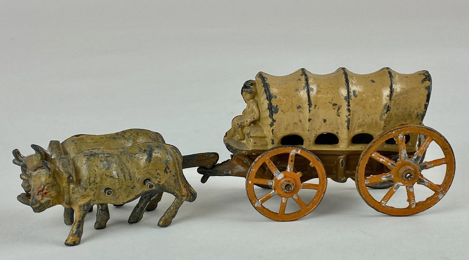Cast Iron Covered Wagon with Oxen: Cast iron and painted early set of wagon and and ox team, wheels function and turn smoothly. 7.25" lg.