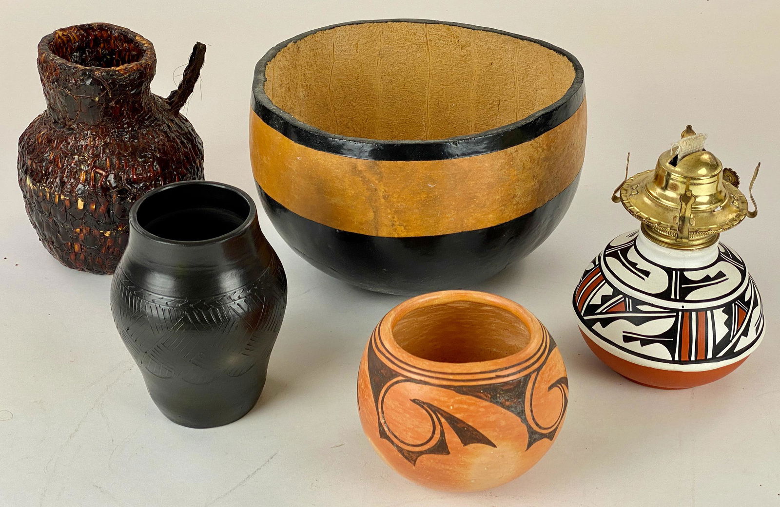 Collection of Southwestern Baskets and Pottery: Including a large gourd bowl, a Cherokee vase by Maney, an M. Sequi pottery vase, a woven basket, and a converted pottery lamp. 10" ht. for largest gourd.