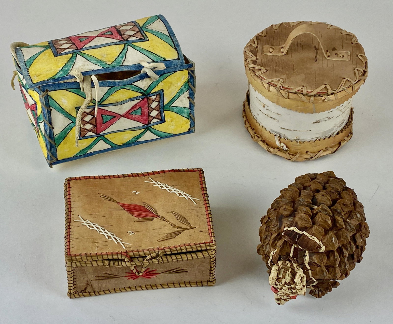 Collection Of Small Western Containers: Lot of four (4) small Native American and Western containers including two lidded birch bark boxes, a one-piece painted box made of hide, and a charming woven pine cone armadillo box from the Louisian