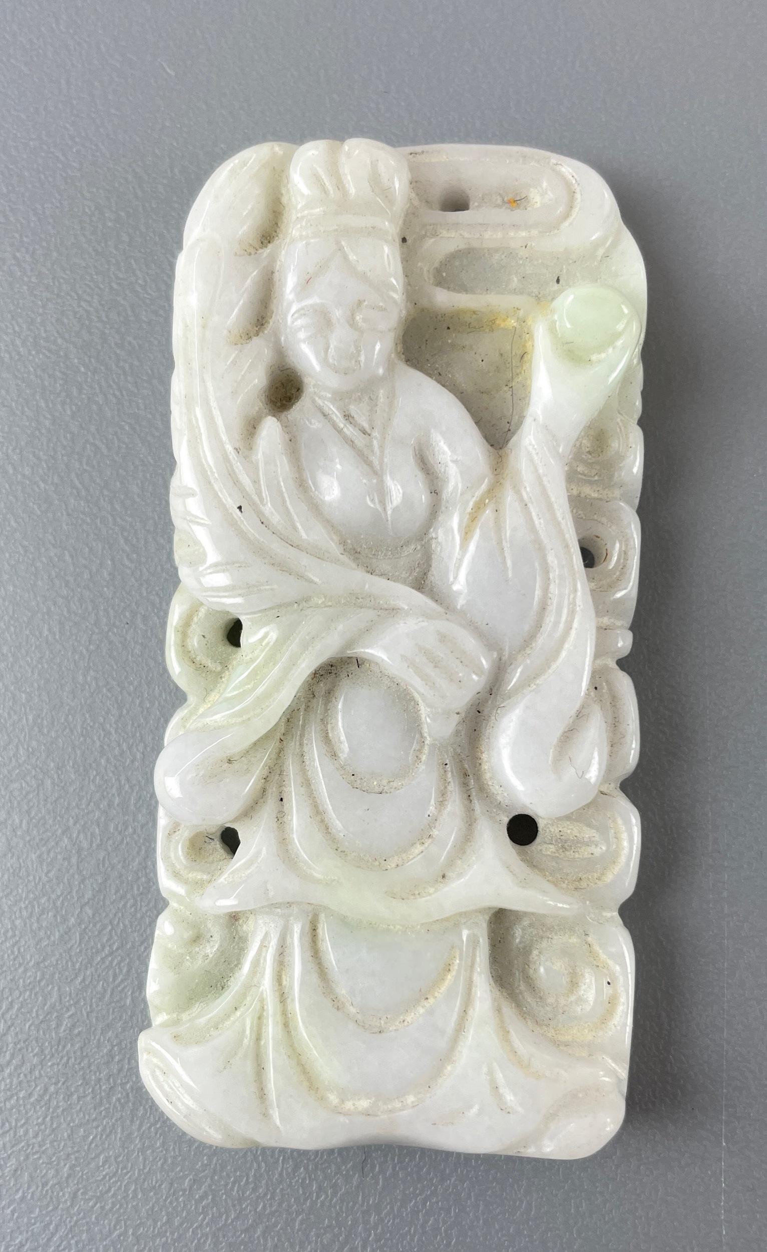 Chinese Carved Jadeite Pendant with Guanyin: A jadeite pendant, 20th century, carved to reveal a Guanyin holding a pearl. Ht. 2.75".