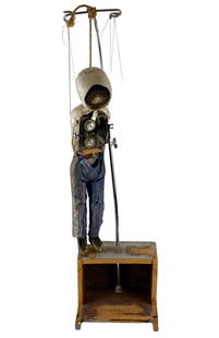 Mark Fox Puppet Construction: Marionette puppet with gear interior on wood base. Gear interior turns to move gears inside stomach. Puppet head constructed of plaster and old gear. 46" ht. Mark Fox (American, b. 1963) currently res