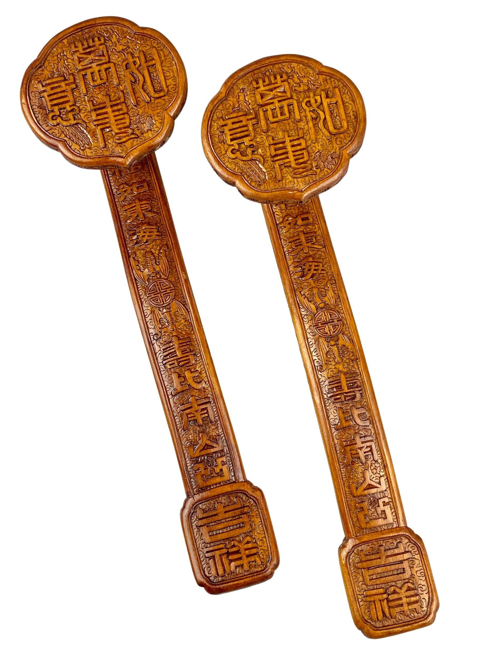 Pair of Chinese Carved Wood Ruyi Sceptors: A pair of near identically carved ruyi sceptors, each with relief carving to reveal characters, bats, and auspicious symbols. Lg. of each 13.75".