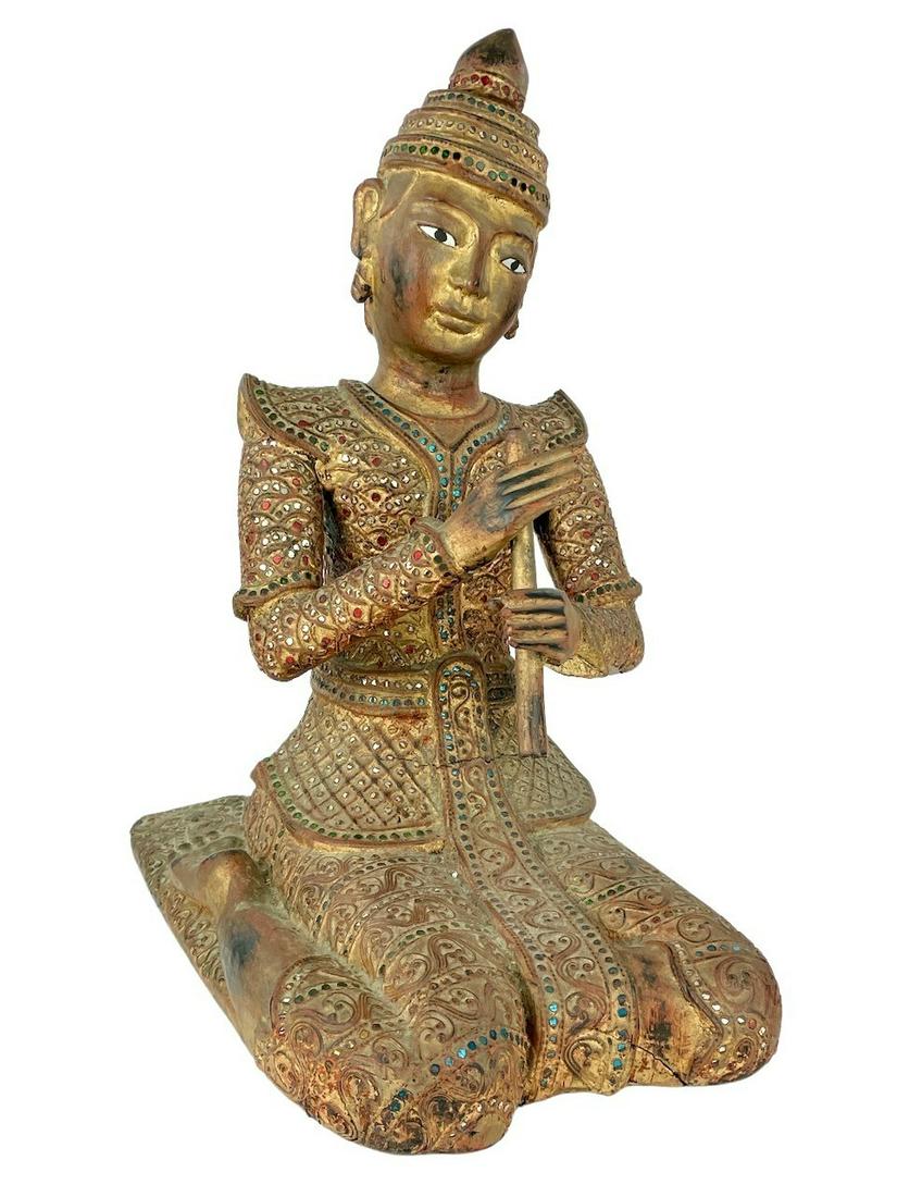 Carved Indonesian Buddha Figure: 20th century, a stone encrusted, gilt and carved kneeling figure. Ht. 19.5".