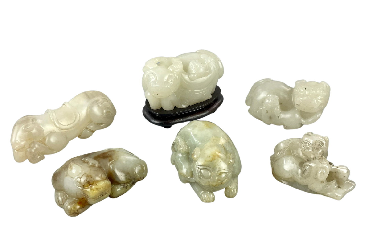 Collection of Chinese Jade Beast Carvings: A group of six carvings, each in jade, with four beast carvings, one water buffalo on stand, and finally a camel carving. Natural light photos included. Longest length 3".