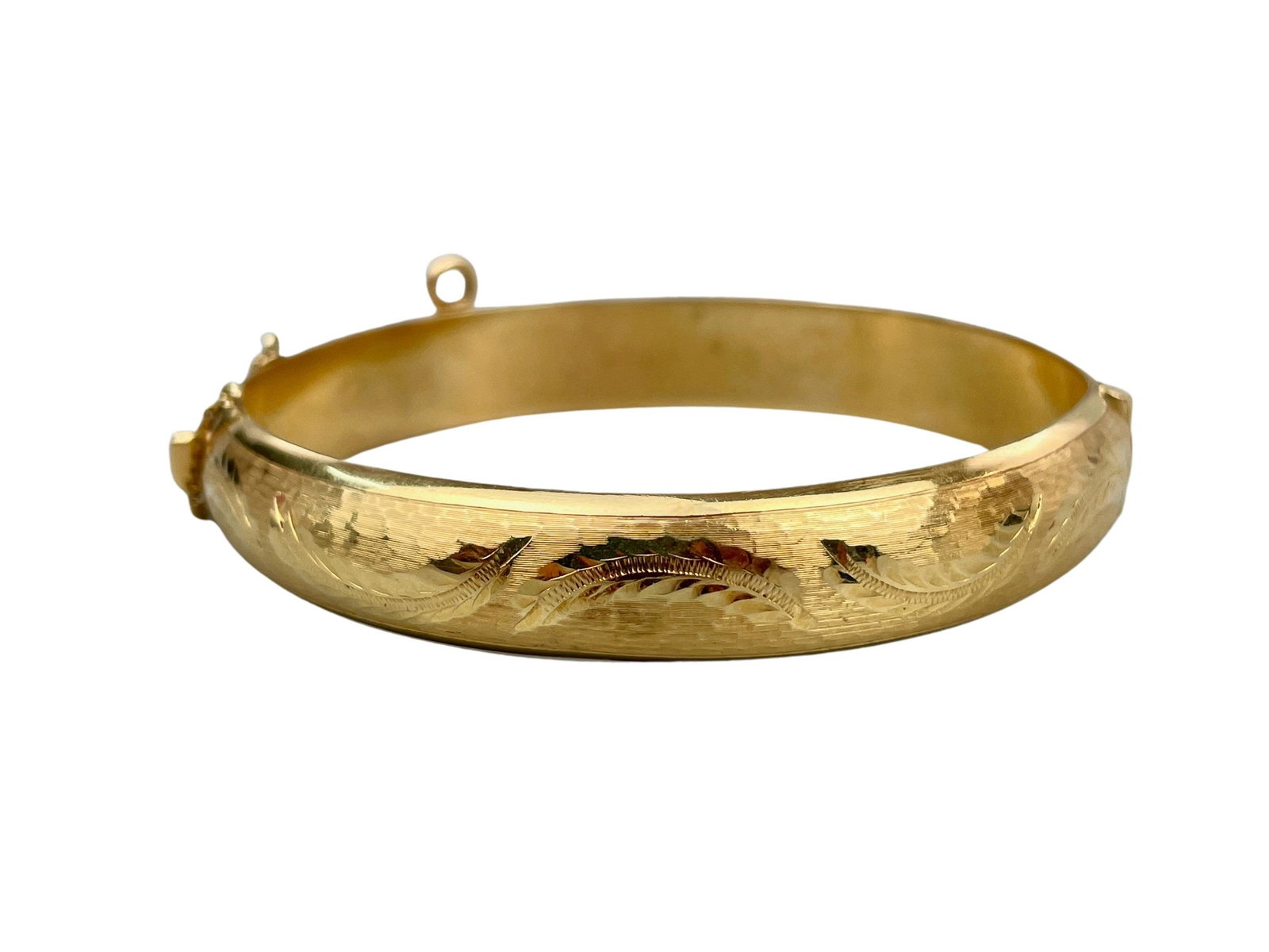 18K Leaf Designed Bangle Bracelet: An 18k gold bracelet, marked to latch, and with hammered design and leaves to exterior. Diameter 2.5", total weight .67 ounces.