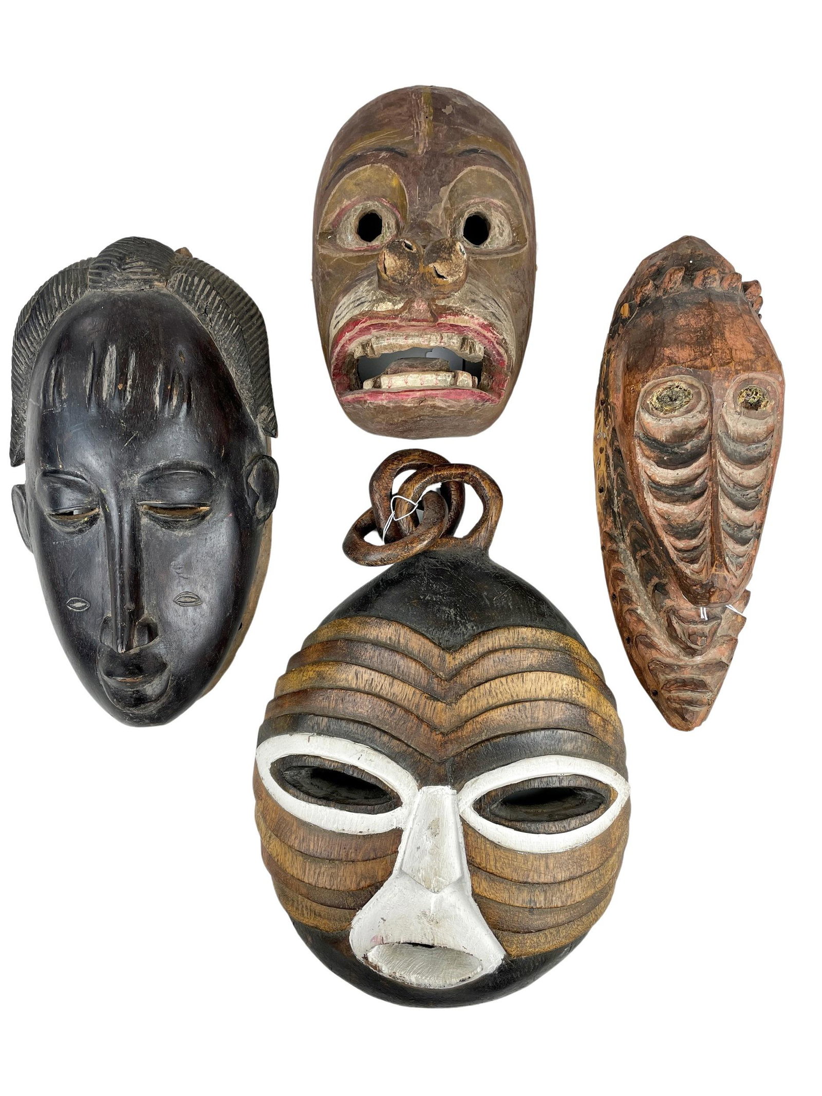 Group of Four Wooden Carved African Masks: One with elongated face and two with paint. Longest: 18"