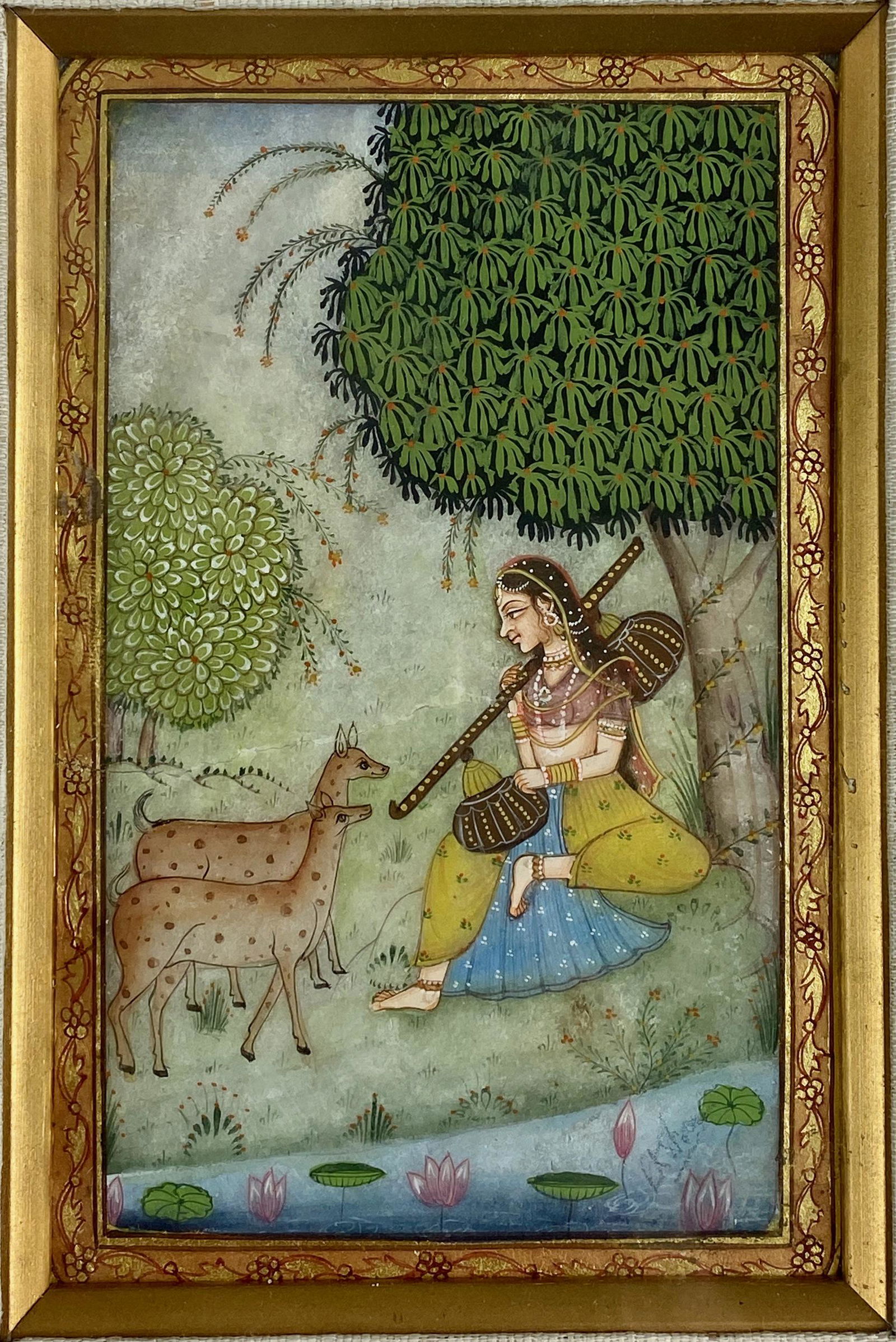 Indian Miniature Genre Painting: 19th Century, a tempera and watercolor miniature painting, with stylized gilt border and a lone female among fawn. Housed in a giltwood frame with linen liner. 5.5" x 3.5" (sight), 10" x 8" (framed).