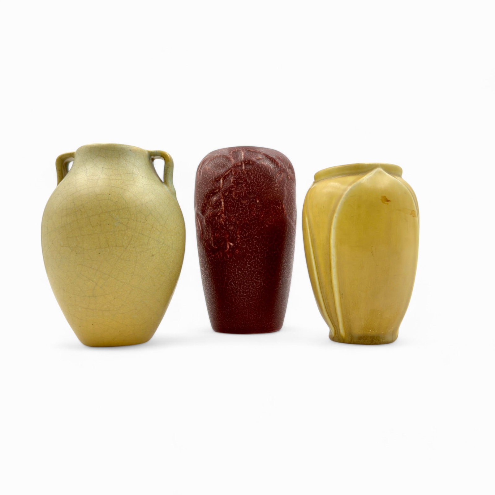 Group of 3 Rookwood Pottery Vases: Three vases of production ware in various glazes and styles. Including a "cracked ware" style vase, a lotus vase, and a mottled red glazed berry and branch vase. Ht. of tallest 6.5".