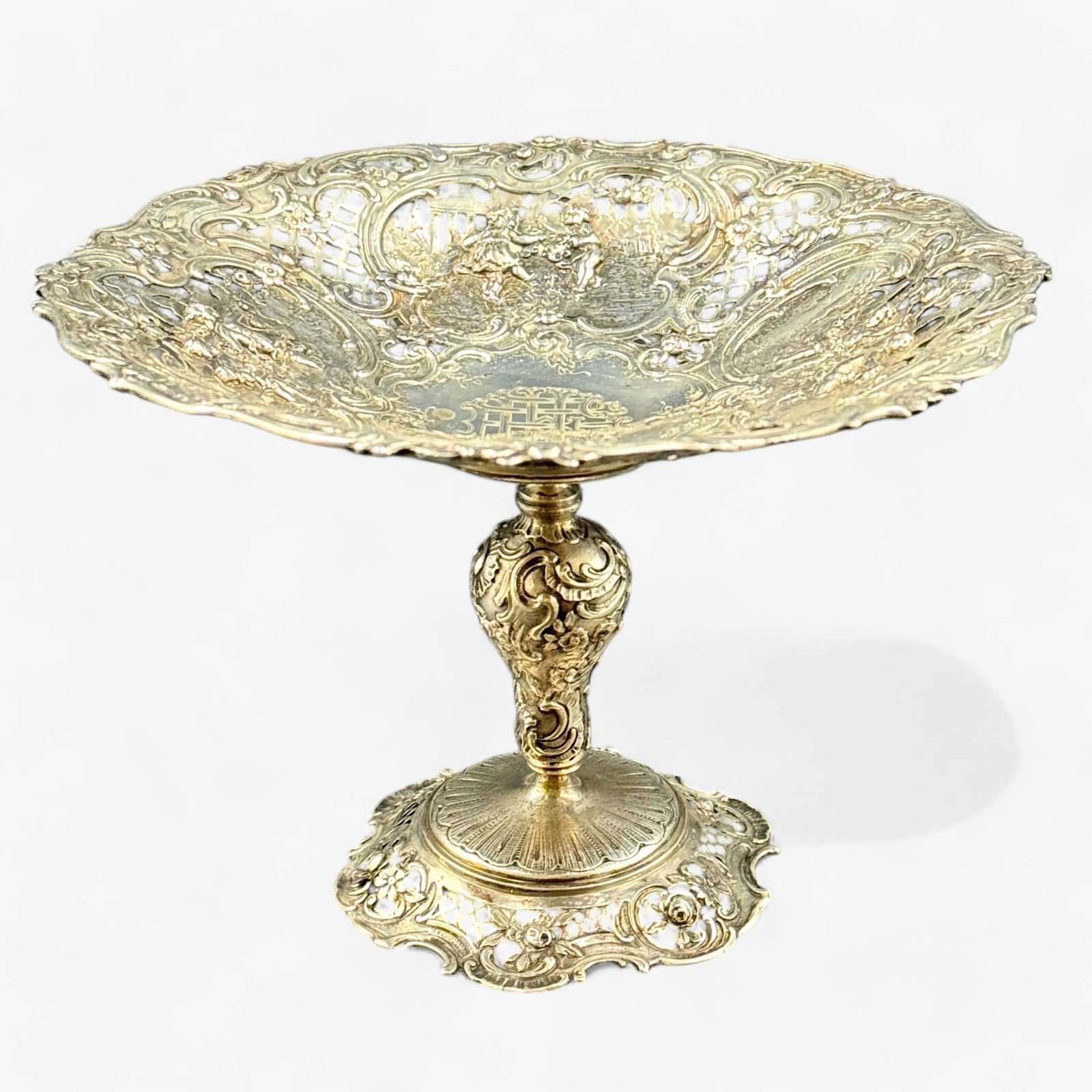 German Sterling Silver Repousse Tazza: Marked to the base with "Sterling, Germany". Base is decorated with fruit and florals, dish component decoarted with cherubic figures and scrolling florals. Height: 6", total weight: 13.46 troy ounces
