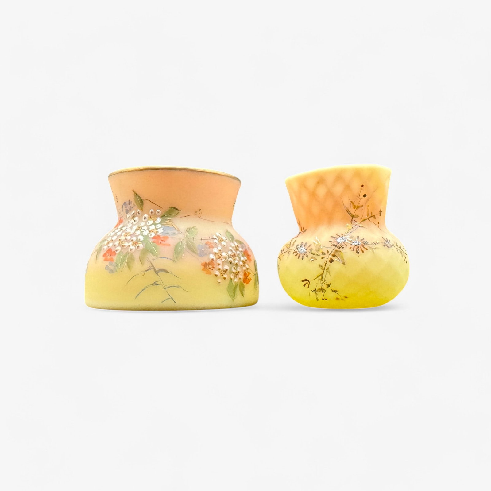 Pair of Mt. Washington Burmese Glass Vases: Pair of diminutive vases, both surface decorated in florals. Tallest is 2.75" ht. x 4" diameter.