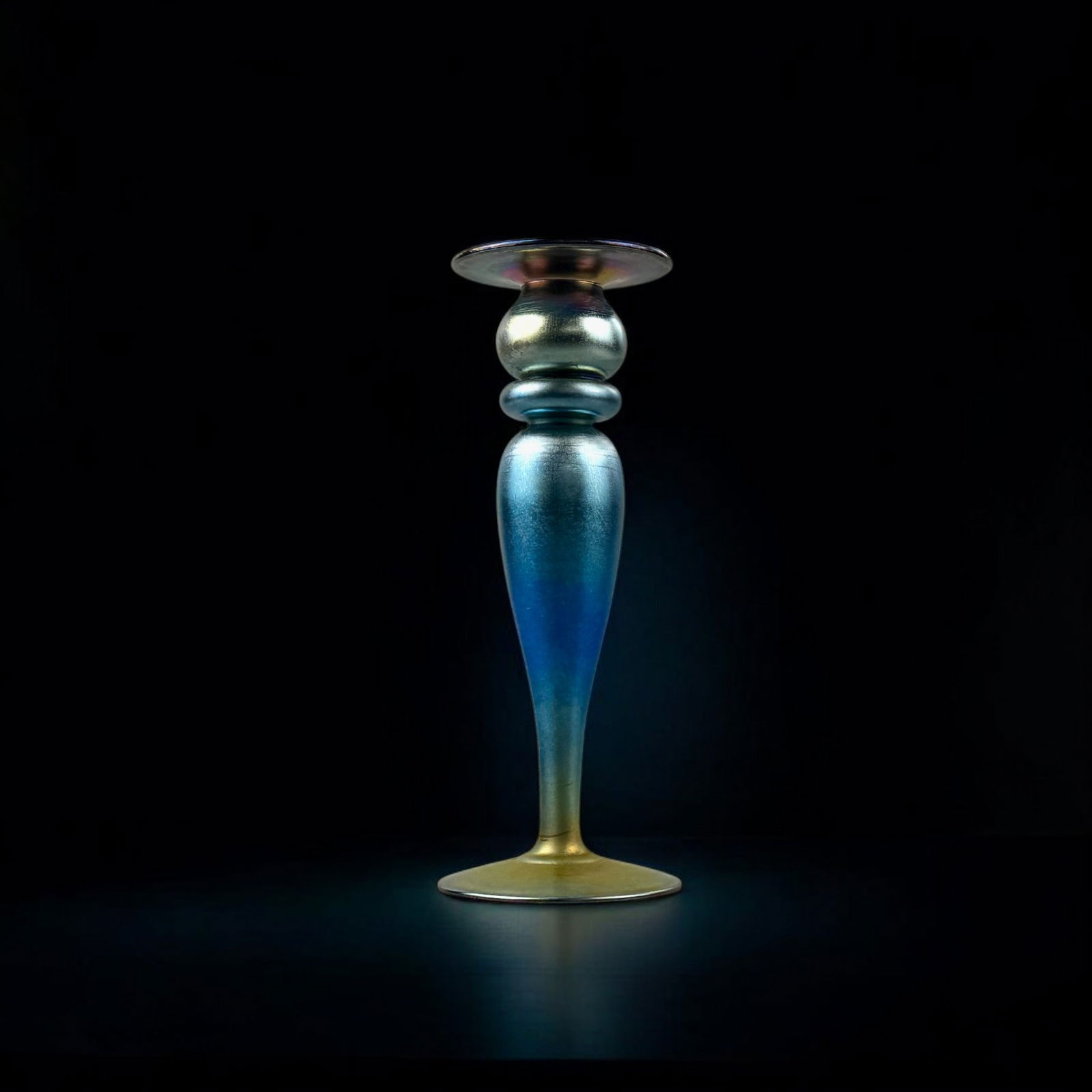 Durand Art Glass Candlestick: An iridescent candlestick, marked Durand to underside, with a shifting blue to gold surface. Ht. 9.75"