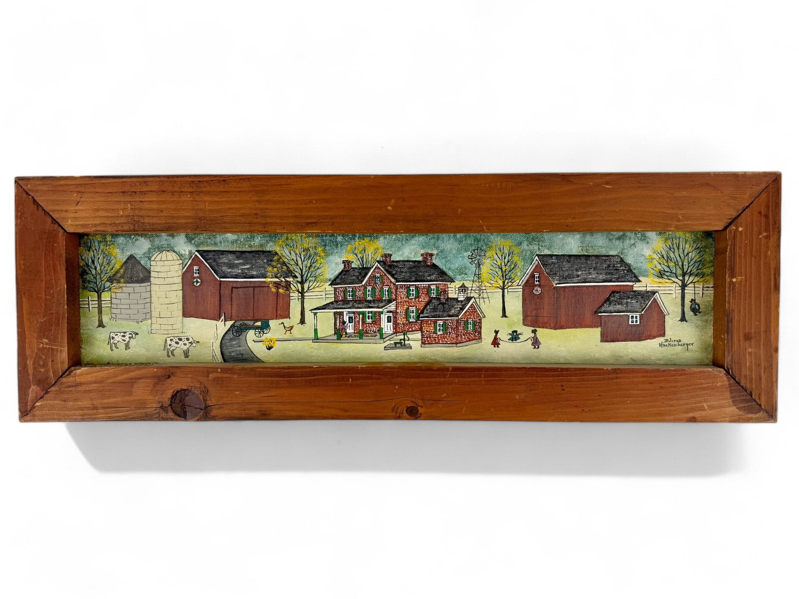 Folk Art American Village by Dolores Hackenberger: Dolores Hackenberger (American, b. 1930). Oil on canvasboard, depicting an Amish village, signed l.r. 4.5" x 21.5" (sight), 8.5" x 25" (framed).