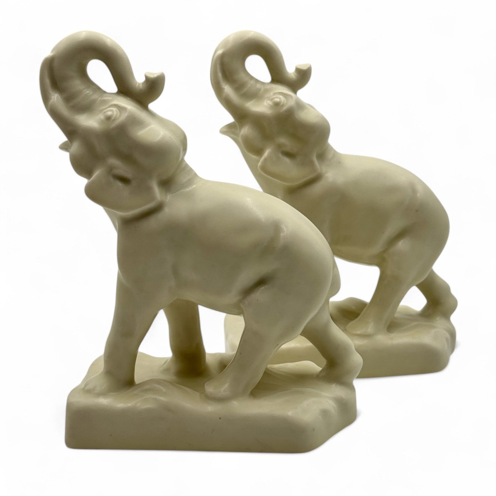 Rookwood Pottery: Trunks Up Bookends: Rookwood elephant trunks-up bookend pair done in white glaze. Shape 6124. 1936. Each 7" ht.