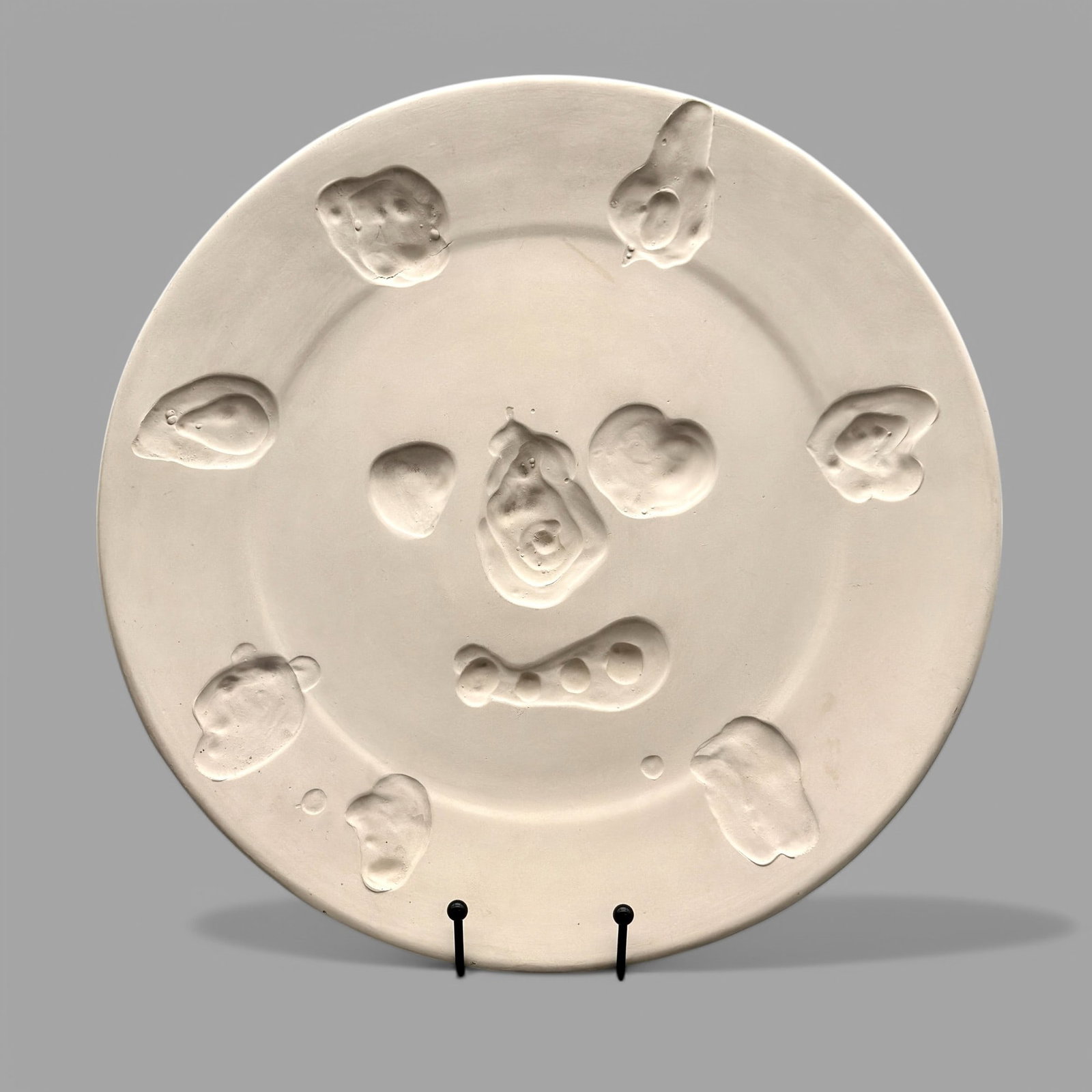 Pablo Picasso (Spain, 1883-1971), Madoura: Madoura titled "Visage aux taches" (A. R. 349) Terre de faïence plate, 1956, numbered 4/100 and incised 'C. 118', with the Empreinte Originale de Picasso and Madoura stamps. 16 3/4" diameter.