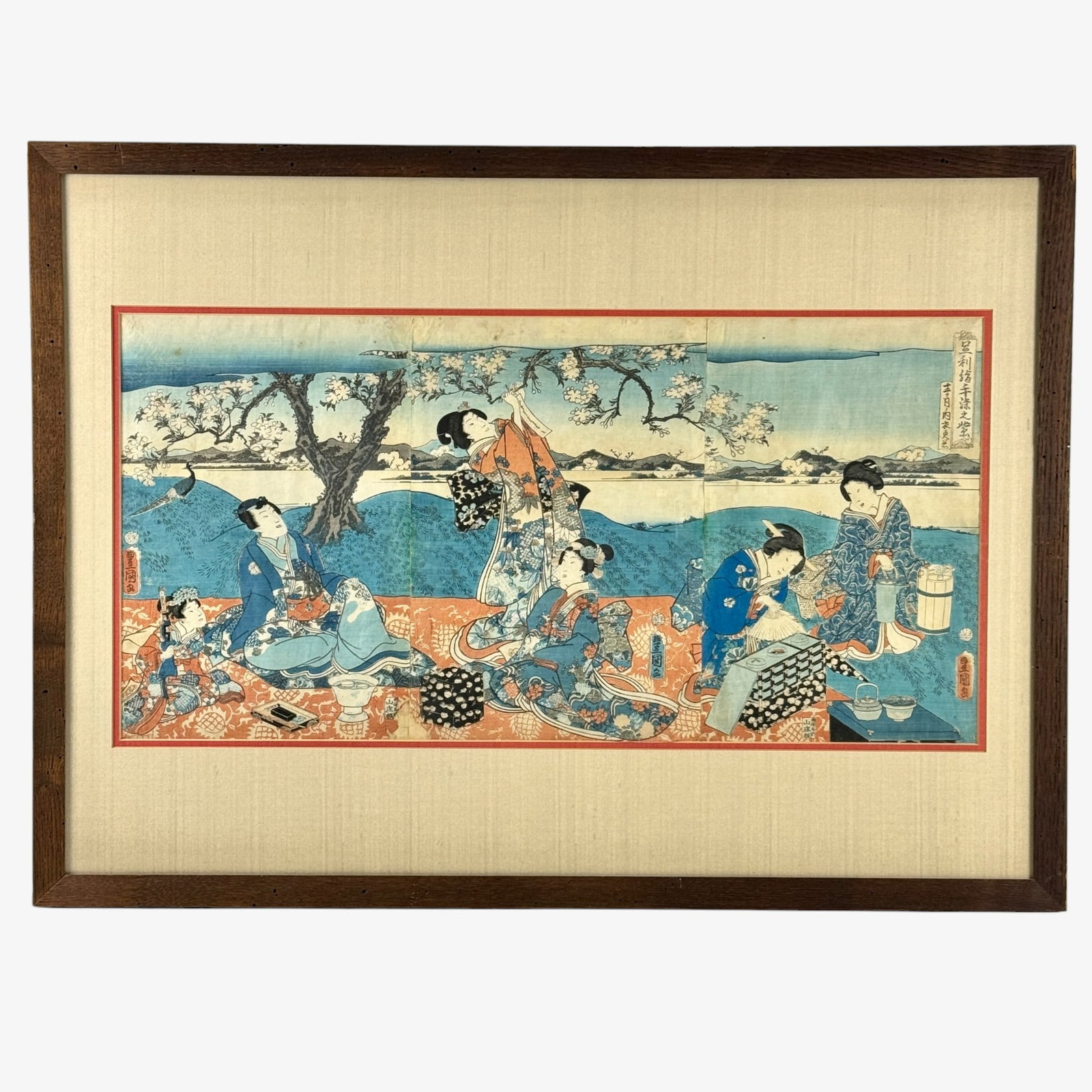 Japanese Woodblocks, Toyokuni and Kunisada: A pair of triptych Japanese woodblocks, including a Kunisada depiction of a female procession and a Toyokuni depiction of a young lord with women amongst cherry blossoms. Toyokuni sight size: 14" ht. 