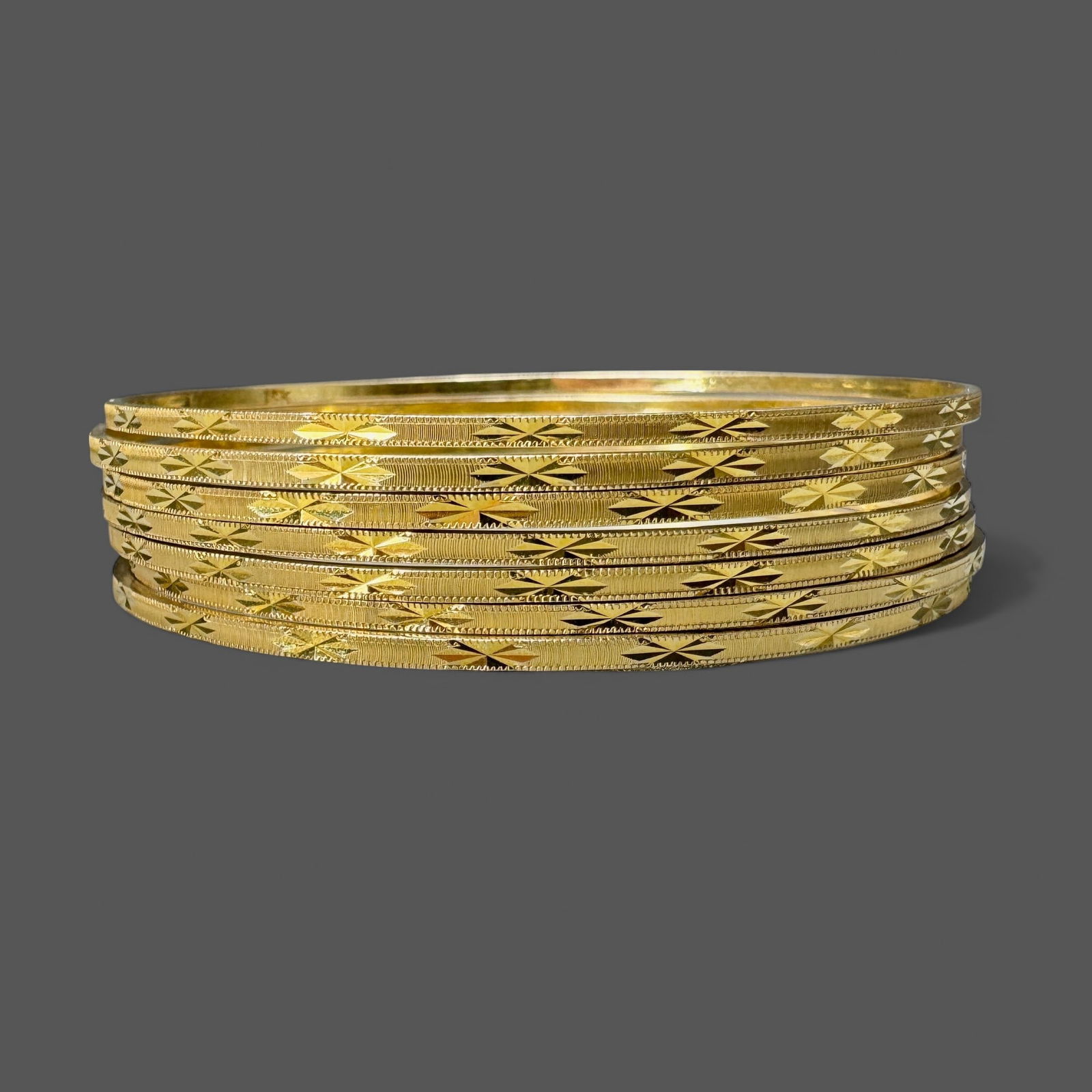 Set of Seven 12k Gold Bangles: Total weight: 1.17 troy ounces Property from the Estate of June Herschede (1930-2025), of the Herschede Jewelers and Herschede Clock Company fam