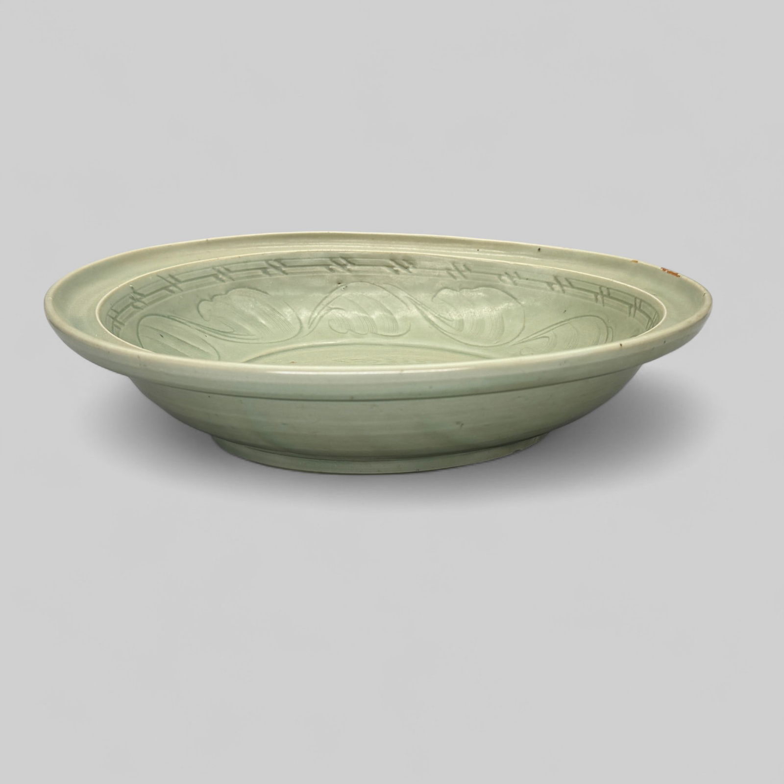 Longquan Celadon Incised Twin Fish Charger: Song or Yuan dynasty, a large "twin fish" designed charger, with plain exterior body and interiorwith carved elements, including the fish. Diameter 13.5".PROVENANCEPrivate Midwestern Collection, acqu