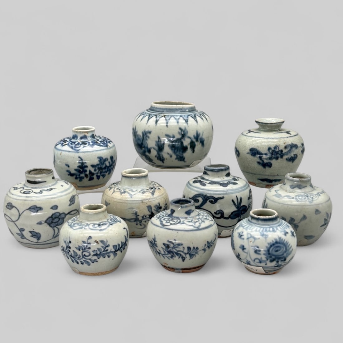 Ten Ming Period Blue and White Decorated Jars: All decorated in the round with vines/floral patterns. Some decorated near the lip with starburst and heart pattern, scrollwork patterns as well. Tallest height: 3.5", widest diameter: 4" PROVENANCEP