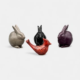 Four modern day Rookwood items. 3 rabbit paperweights and one cardinal ornament.