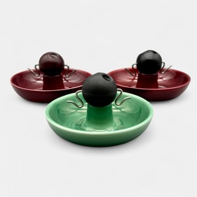 Three late Rookwood ashtrays with wooden holder.