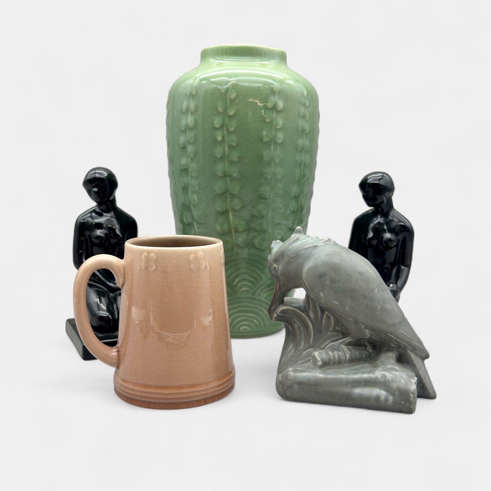 Five Rookwood production items.: Five Roowood production items. Single kingfisher bookend, shape 2687, 1924. Pair of Townley era "Nude" bookends in black, Shape 6159, dated 2000. Falls City Beer mug, no shape, 1948. Tall green vase w