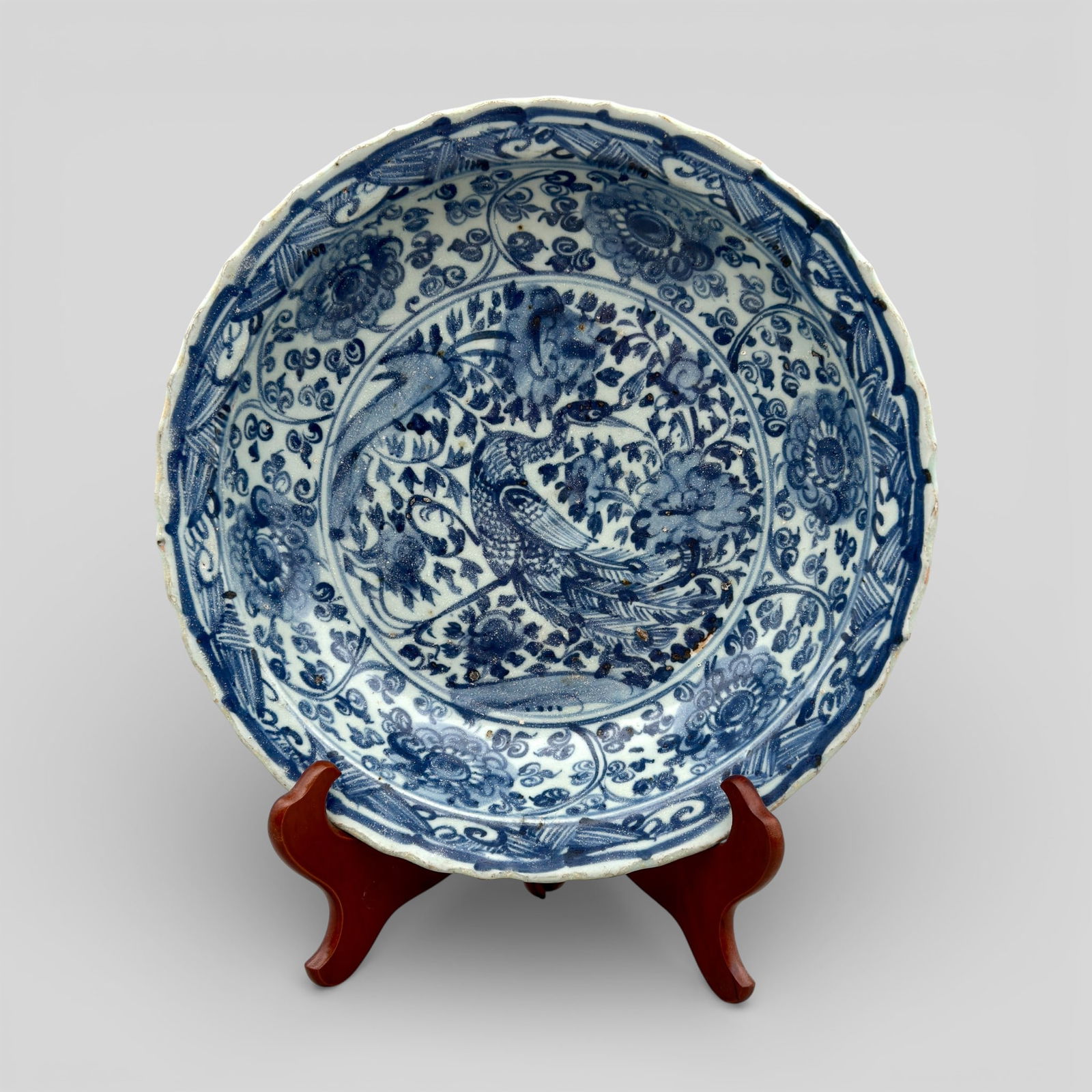 Mind Blue and White Porcelain Dish: A large dish with a flattened, foliate rim has a depressed base, surrounded by a band of unglazed paste. The decoration is the same as the previous lot, except that this dish has no band below the out