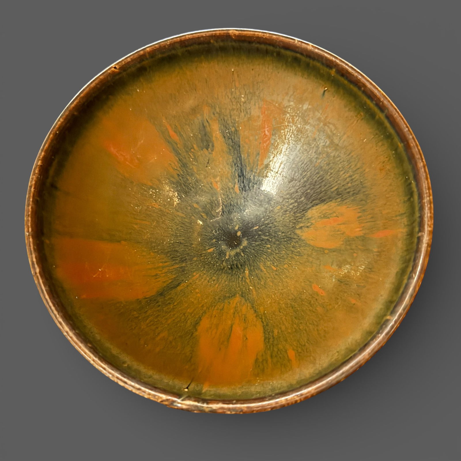 A Jian "Hares Fur" Bowl: Southern Song dynasty. A larger example, russet streaked and dashes of russet to interior. Heavy glaze drips halfway down the bowl, foot is unglazed. Diameter: 7" PROVENANCE</