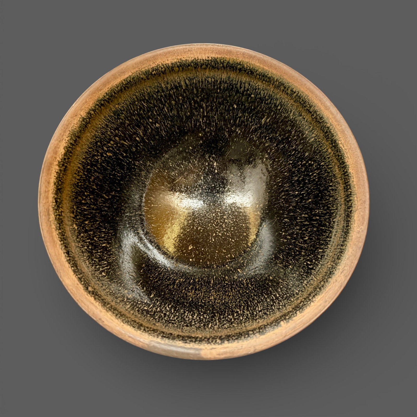 A Jian "Hares Fur" Bowl: Southern Song dynasty. With russet streaks thoughout the interior and exterior of the bowl. Glaze is in fine shape and pools together nicely toward the foot. Diameter: 4.75" PROVENANCE