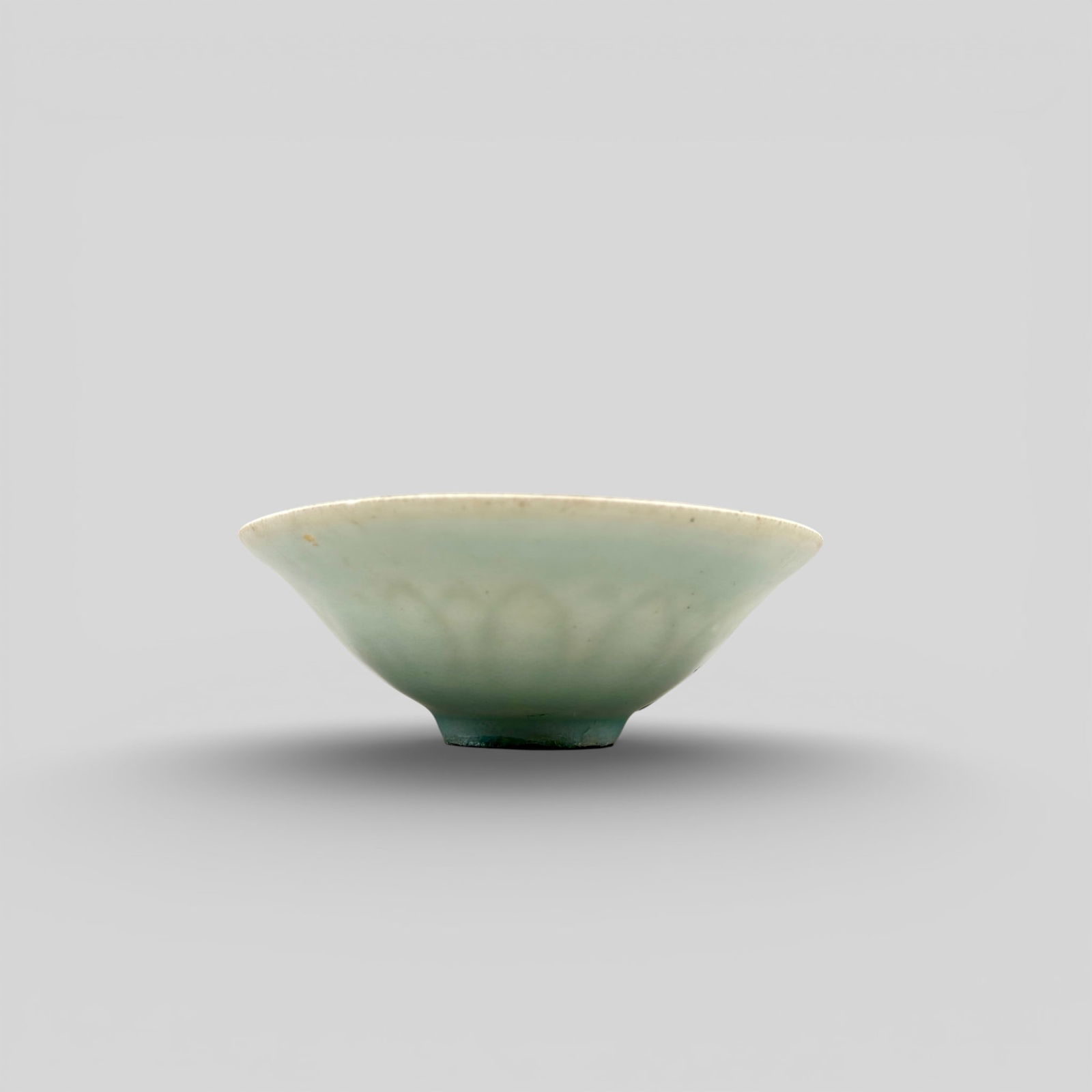 A Carved Qingbai Lotus Leaf Bowl: Song/Yuan dynasty. Carved lotus leaves in a pattern to center with geometric design closer to the interior lip. Flared rim, unglazed foot. Diameter: 4.75" PROVENANCE Pri