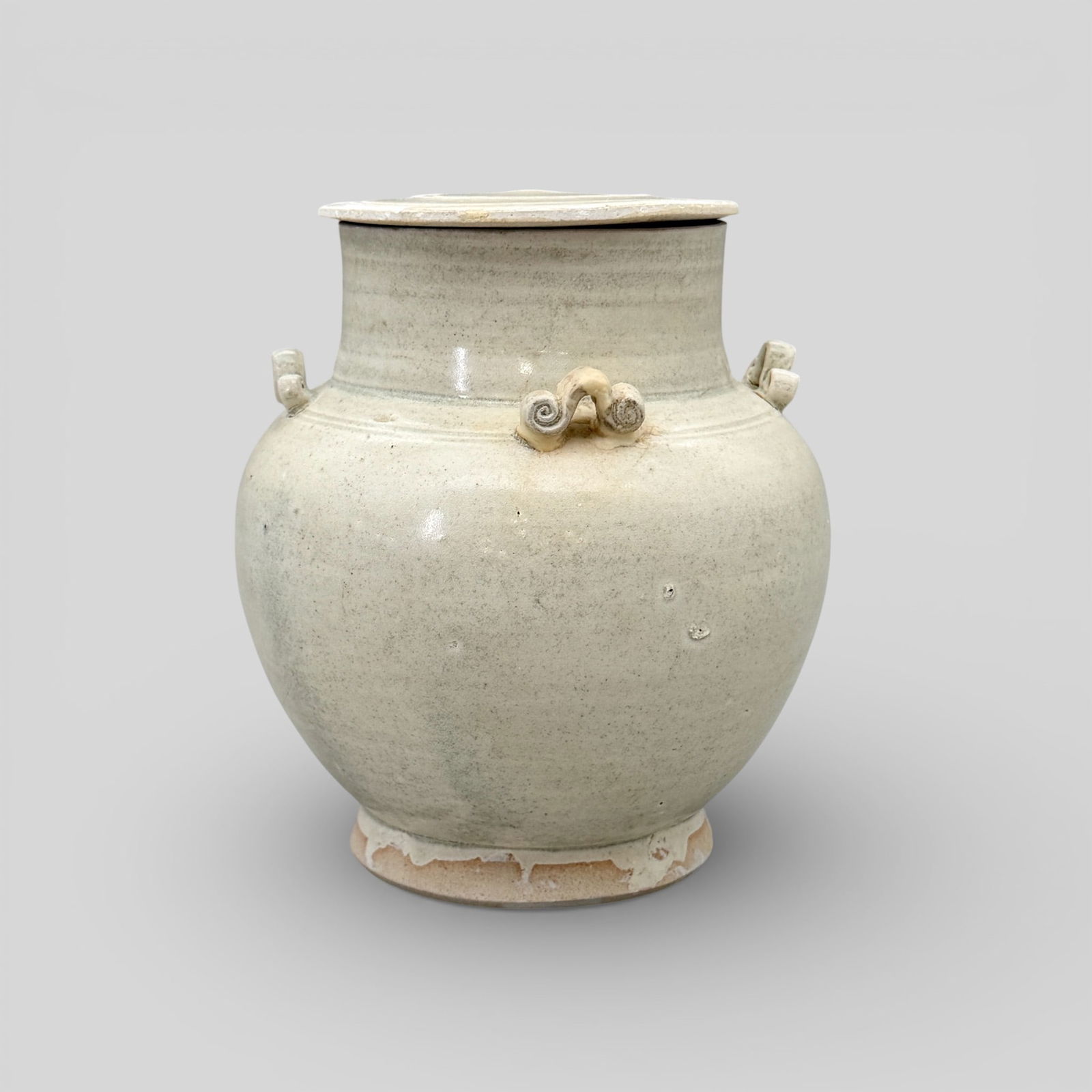 Four-Handled Lidded Celadon Jar: Song/Yuan dynasty. With four scrolled handles and lid. Unglazed interior and unglazed foot. Areas of lid without glaze. Height: 5.75" PROVENANCE Private Collection, Colu