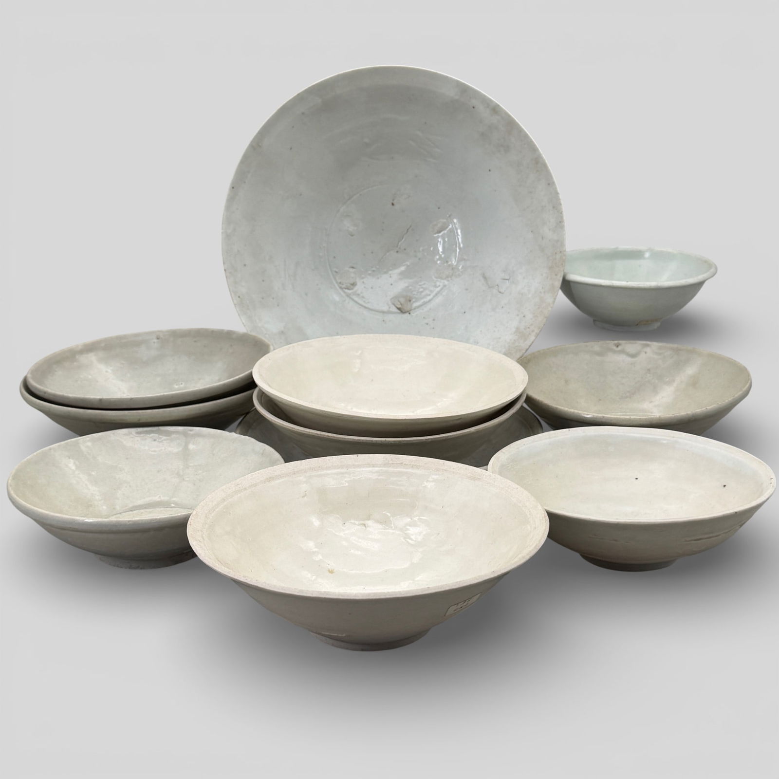 Group of Qingbai Ware Bowls: Song/Yuan dynasty. A group of 11 white to light-blue toned bowls lacking decoration. Largest diameter 11.5". PROVENANCE Private Collection, Columbus OHCollected fr