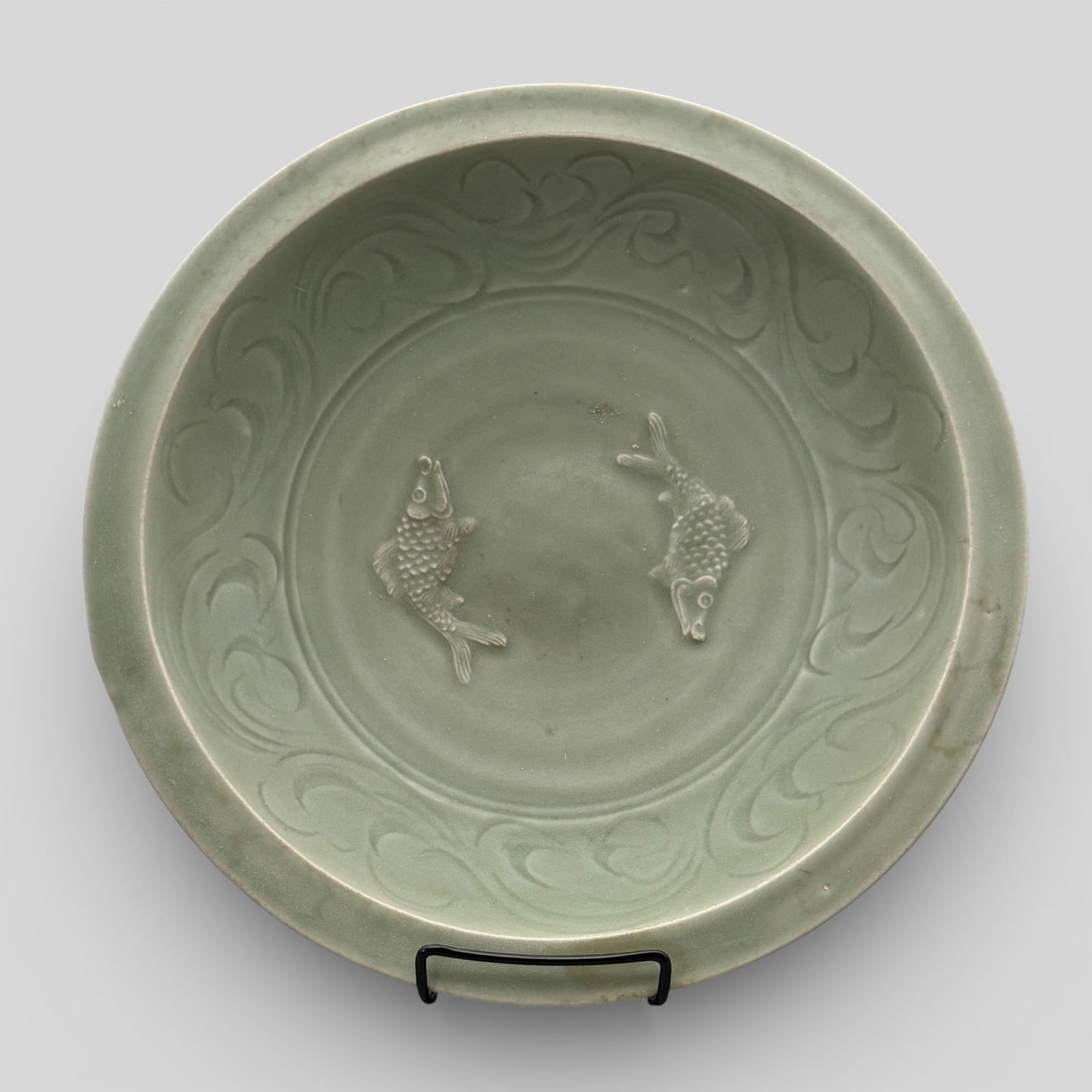 Massive Longquan Celadon "Two Fish" Charger: Song/Yuan dynasty. An longquan celadon "two fish" charger with highly carved and stylized fish to interior. Fish are quite clear. Incised scrollwork to rim around interior. Unglazed foot. Lotus petals