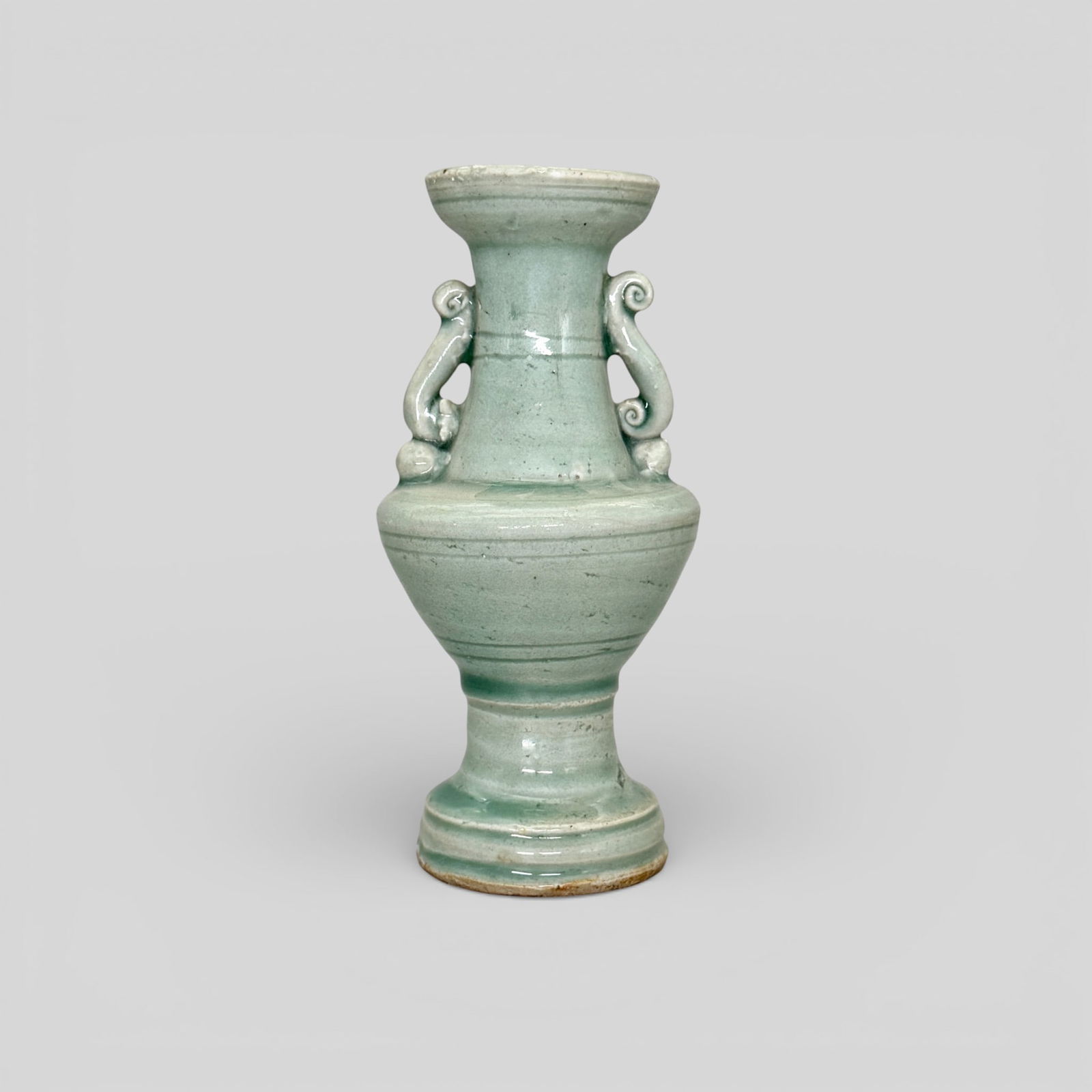 Longquan Celadon Two-Handles Vase: Song/Yuan dynasty. High glaze, with two scrolled handles. Unglazed foot. Height: 7" PROVENANCE Private Collection, Columbus OHCollected from sources in Southeast a