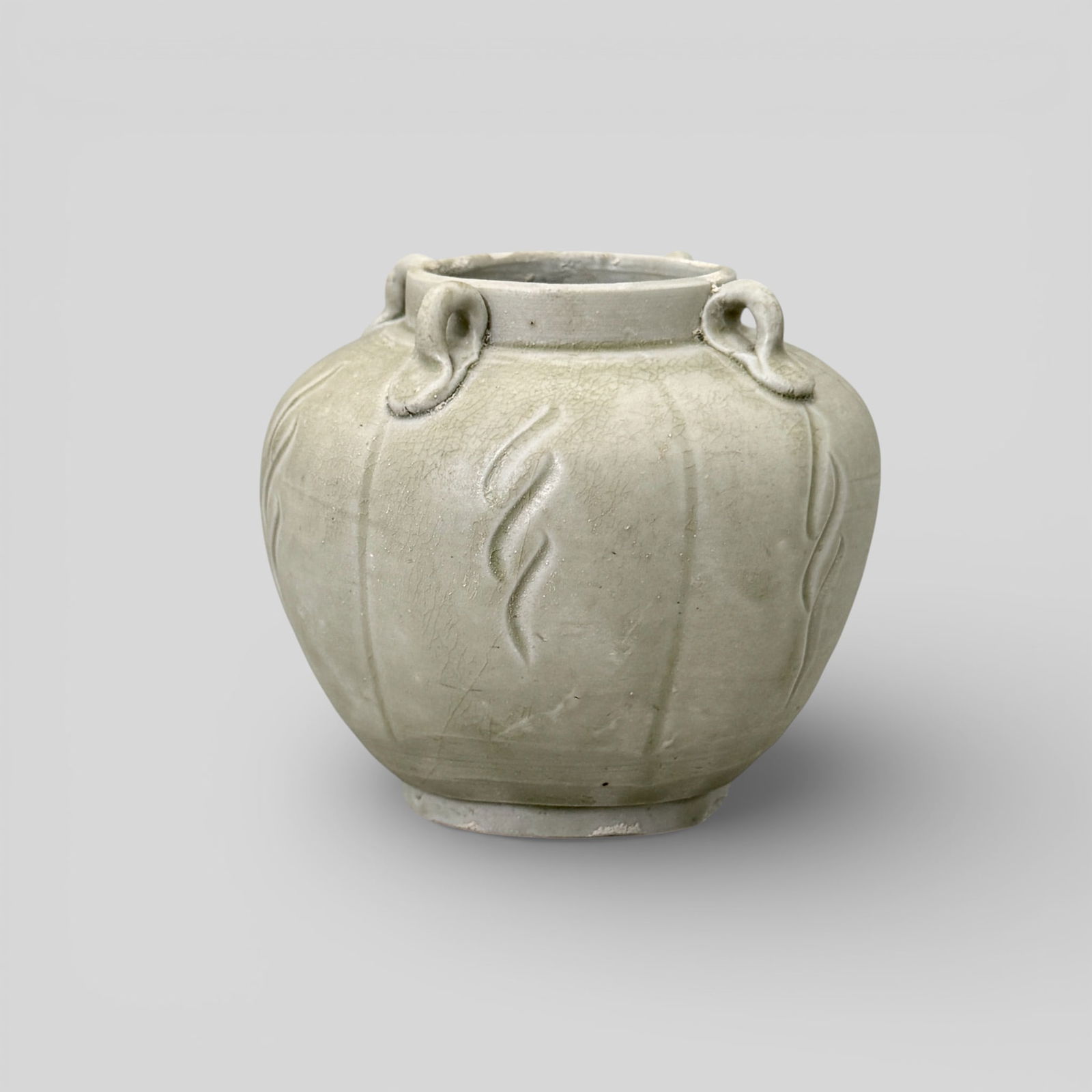Carved Yue Ware Four-Handled Jar: 10th century. A four-handled yue-ware jar with stylized carving to exterior. Height: 4.25" PROVENANCE Private Collection, Columbus OHCollected from sources in Sout