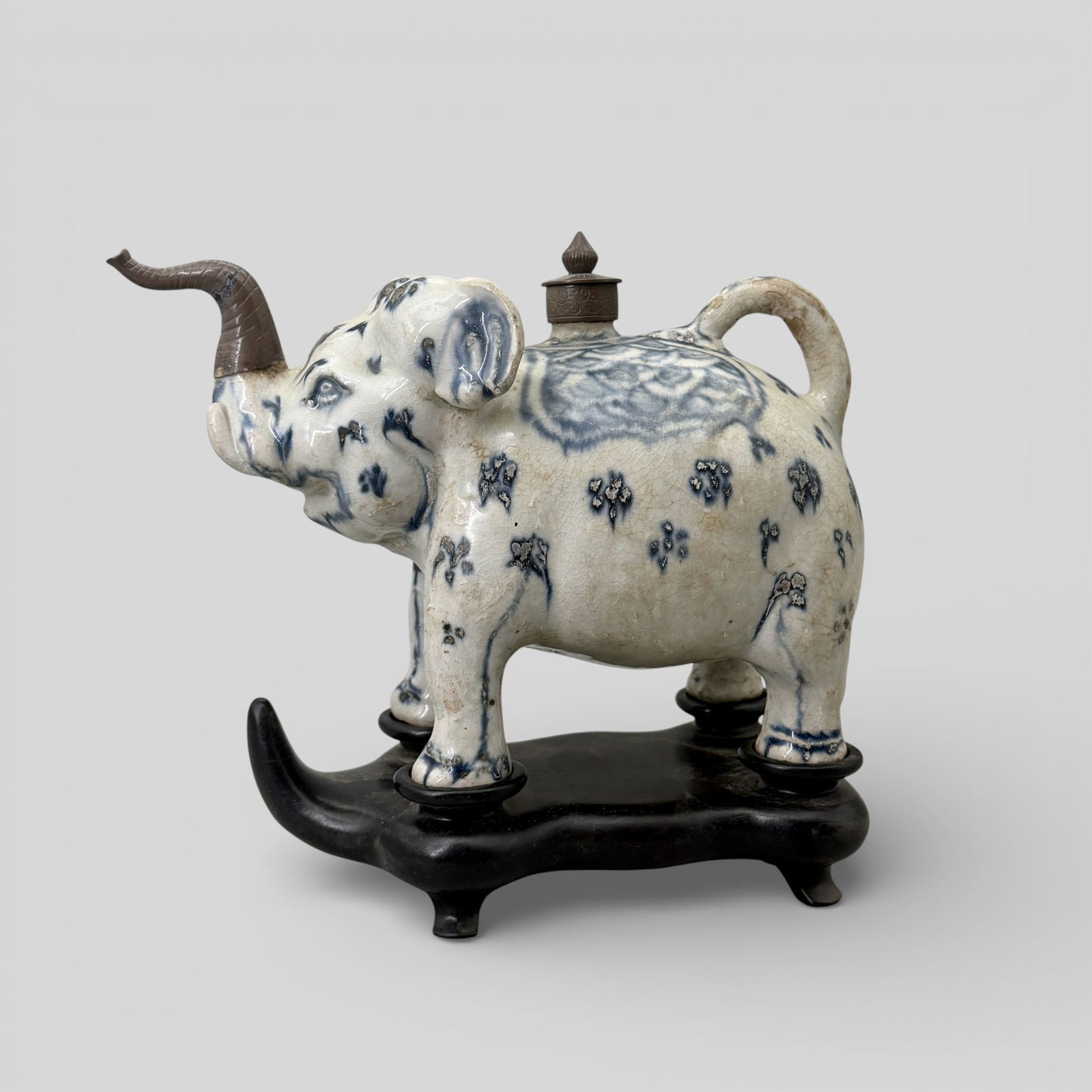 Annamese Blue and White Porcelain Elephant: Circa 15th century, Annamese elephant with underglaze blue and white decoration. In later box and stand for the elephant. Spout and lid constructed of a mixed metal. Tail and spout still fully intact.