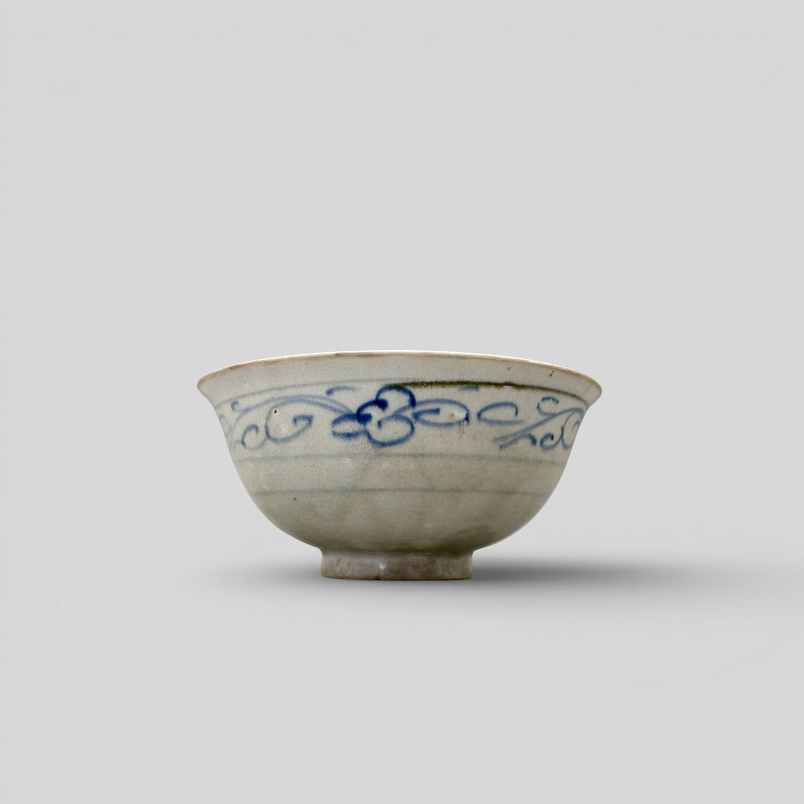 Porcelain Bowl with Underglaze Blue, Yuan: Decorated in an underglaze blue with scrolling floral pattern to exterior and scrolling pettern to interior rim. Floral design to base of center. Heavy crazing throughout. Diameter: 6.5" PROV