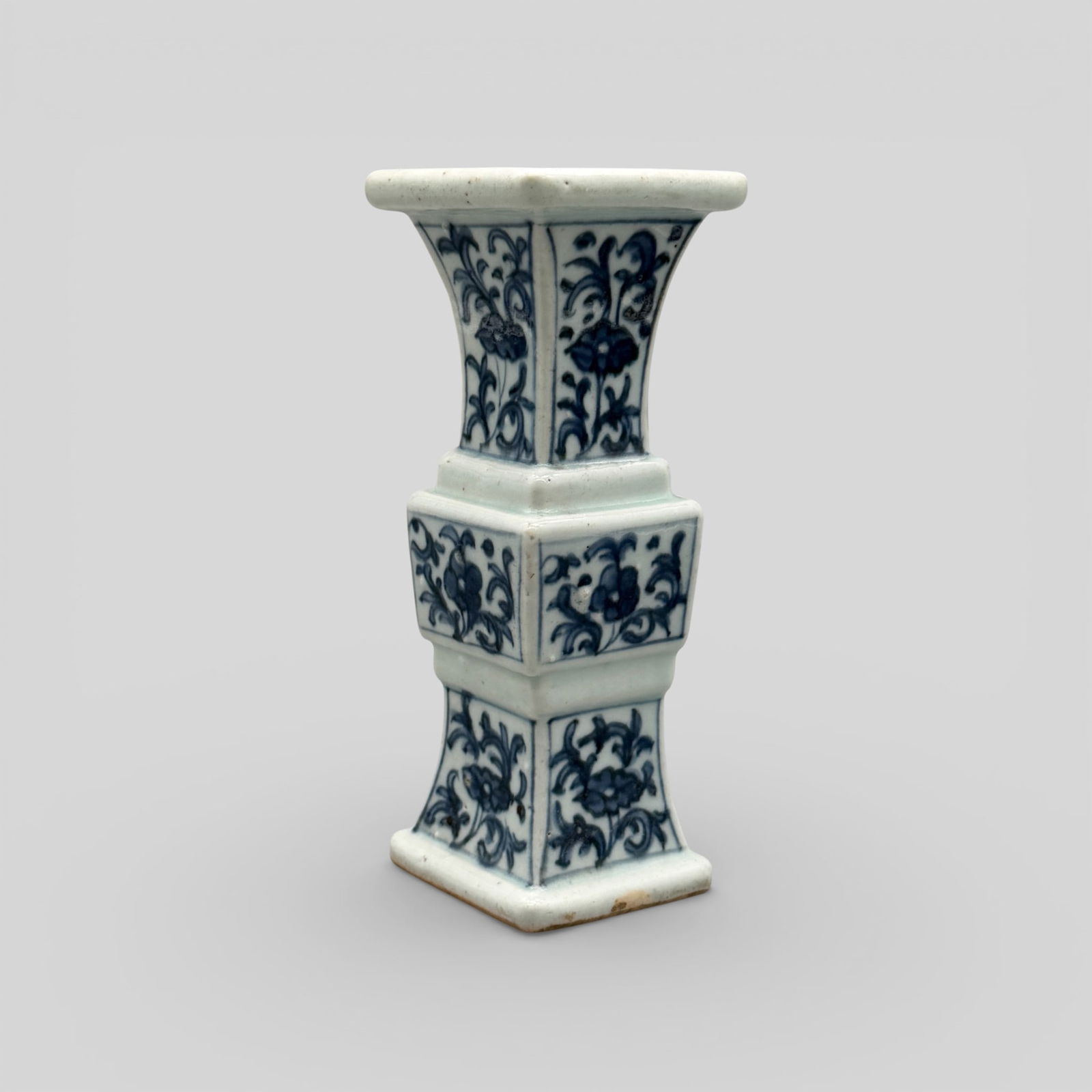 Ming Blue and White Decorated Vase: Ming, 16th century. In geometric form, with florals to exterior, fluted rim and band of underglaze blue to rim. Unglazed foot. Height: 6.5" PROVENANCE Private Collection