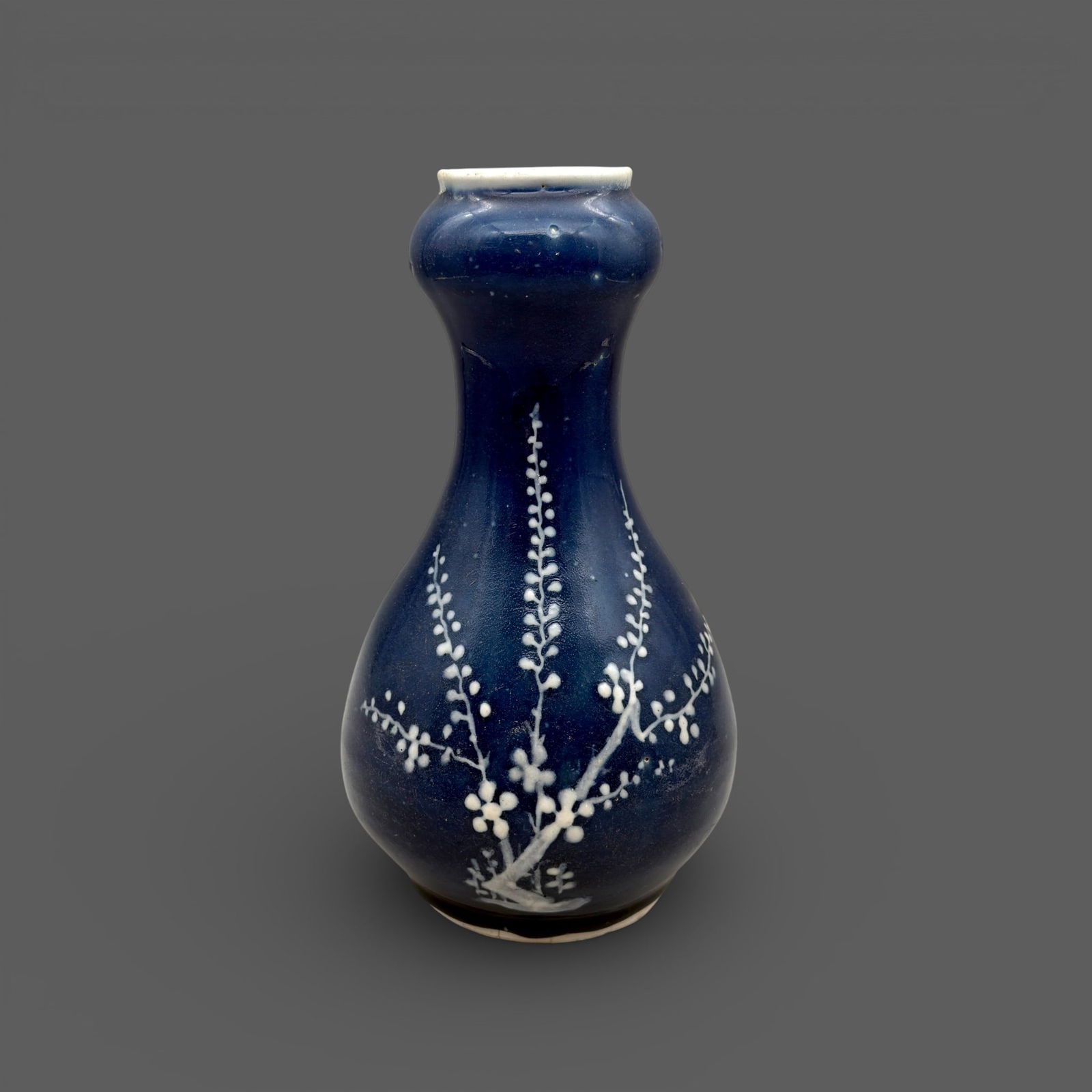 Ming Period Underglaze Blue Gourd Vase: Ming period, an underglaze blue ground with single white flowering branch. Ht. 10" PROVENANCE Private Collection, Columbus OHCollected from sources in Southeast an