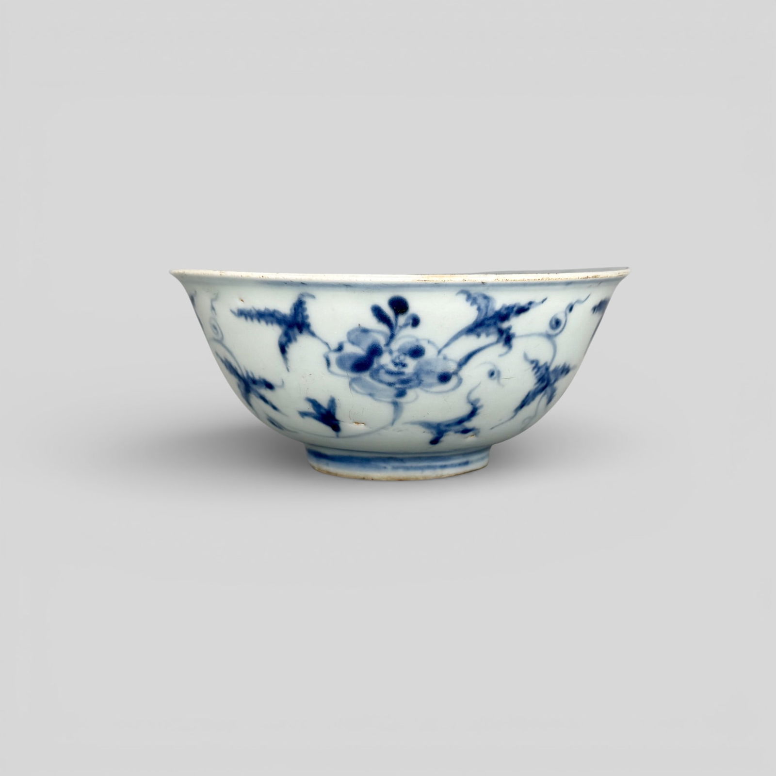 Ming Period Blue and White Floral Bowl: Mid-late Ming period, a blue underglaze decorated bowl in spaced, abbreviated and loose strokes with floral design to exterior and interior. Collector note cites it as Chenghua, and the rim carries re