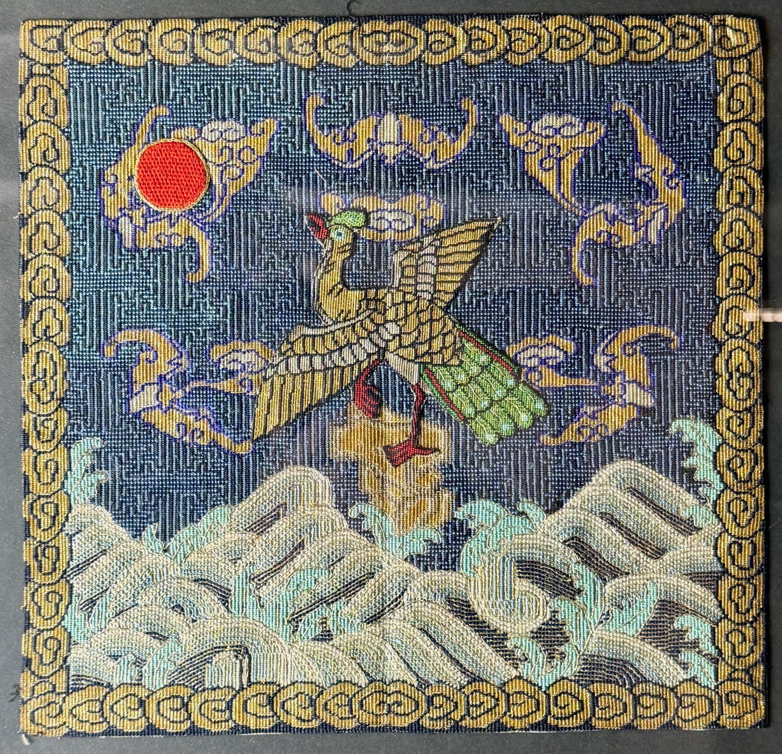 Qing Dynasty Golden Pheasant Military Badge: Golden pheasant to center atop stone with waves. Sun in upper left corner. Gold scrolling cloudlike patterns to exterior. 10.5" ht. x 11" wd. PROVENANCE Private Collecti