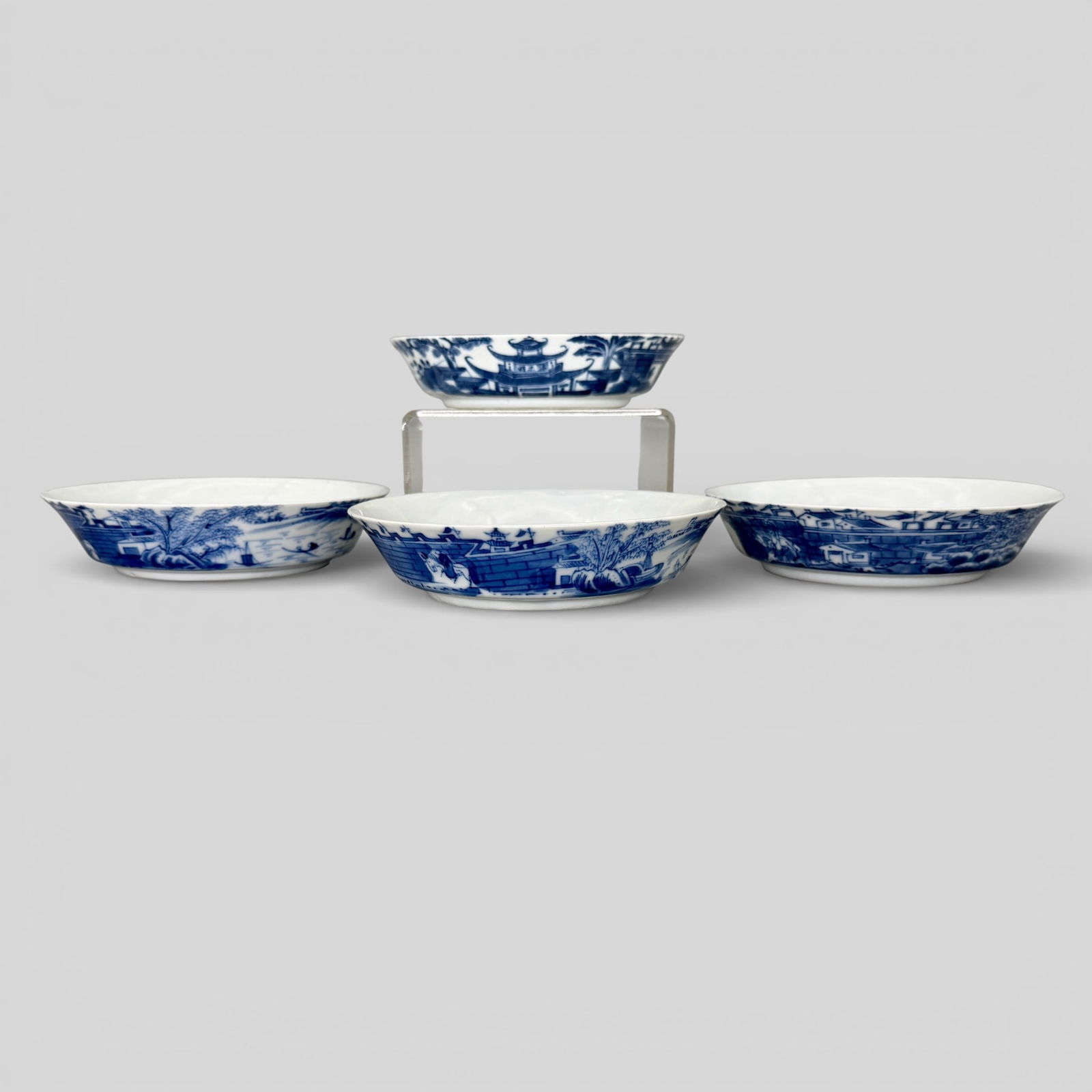 Qing Dynasty Commerical Bowls: Qing period, blue and white porcelain. Marked for "Pearl River", a shop mark, and consisting of four shallow bowls each with fort or city scenes decorated in the round. Each diameter 4.75". P