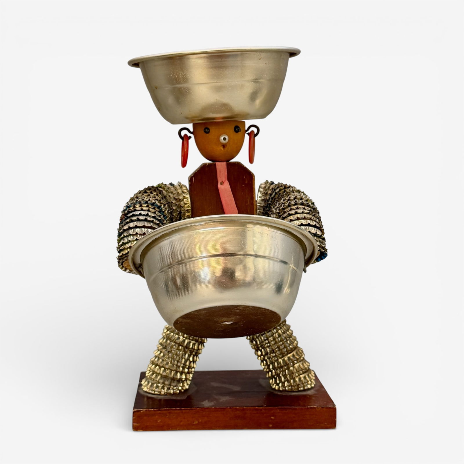 Folk Art doll, bottle caps and wood and small cups: Folk Art doll made of bottle caps, wood, plastic rings and two small bowls. Unsigned. Height 9 1/4 inches.