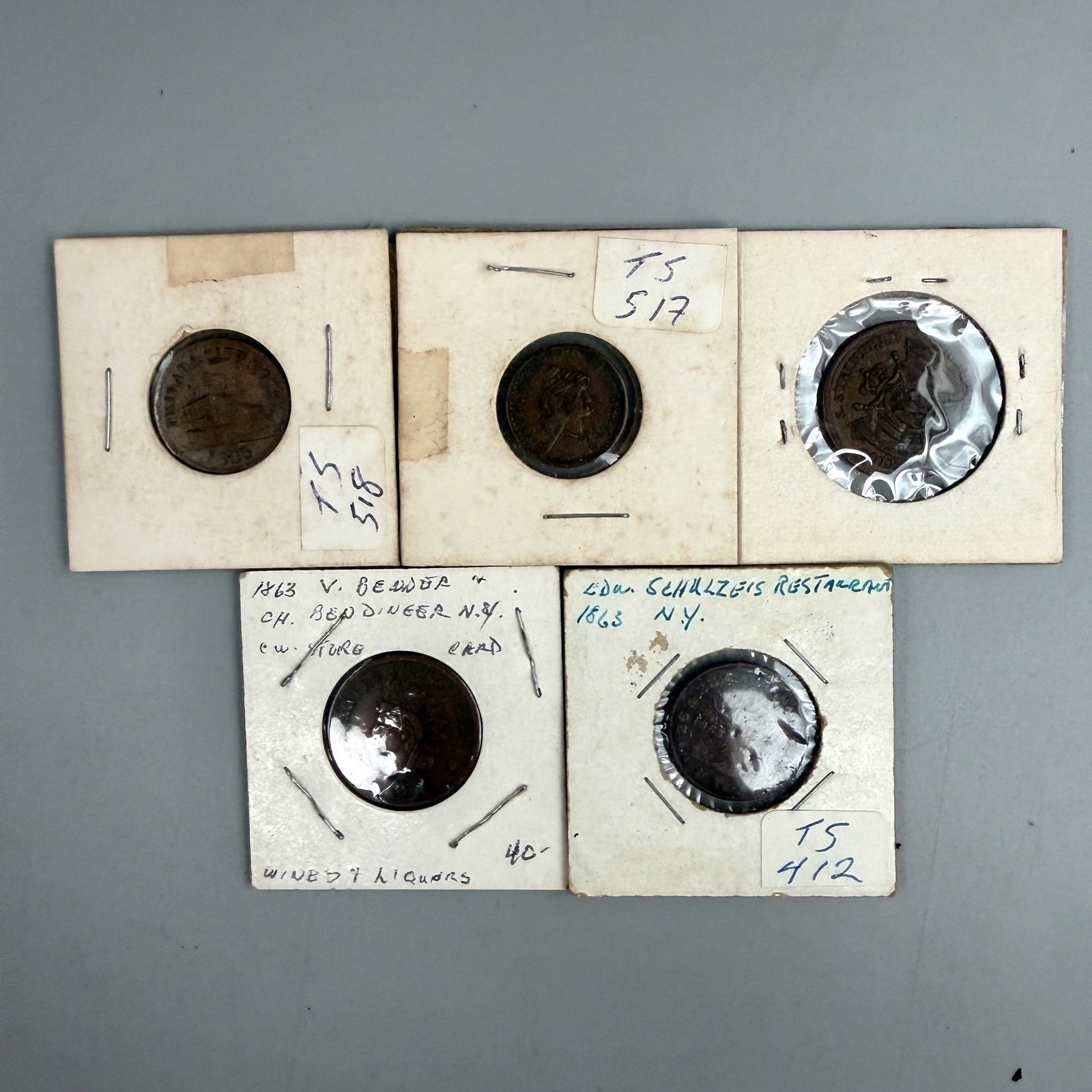 Group of New York and Philadelphia Civil War Tokens: Five Civil War tokens including N.Y. Restaurant stag head; N.Y.C. wine & liquor dealer; French Cognac dealer (Napoleon eagle motif); Broas Bros. New York patriotic token; and Philada. City Hotel token