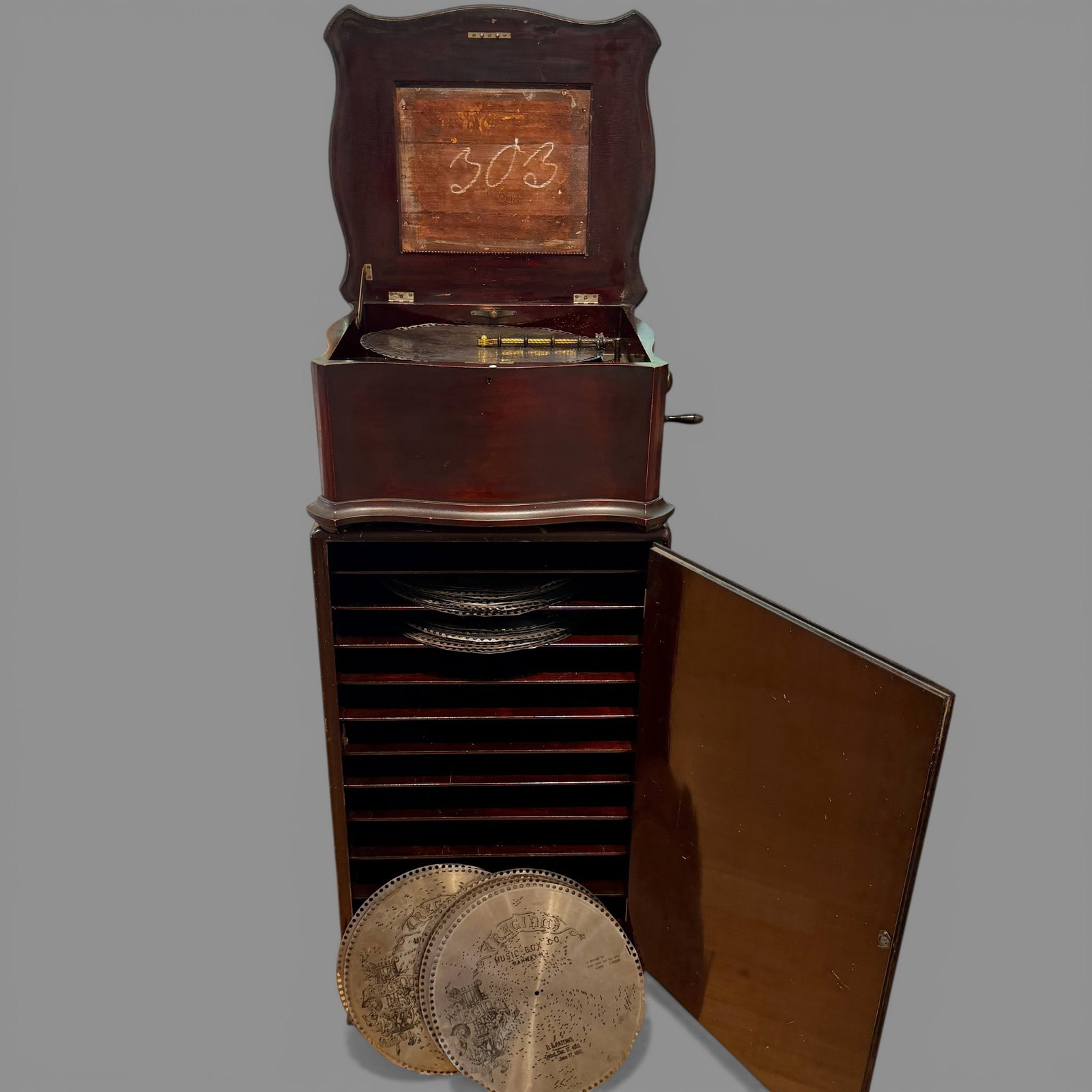 Regina Music Box in Working Condition: A nice Regina music box in working condition. The original label is gone. Accompanied by many discs, and with matching stand to store discs.