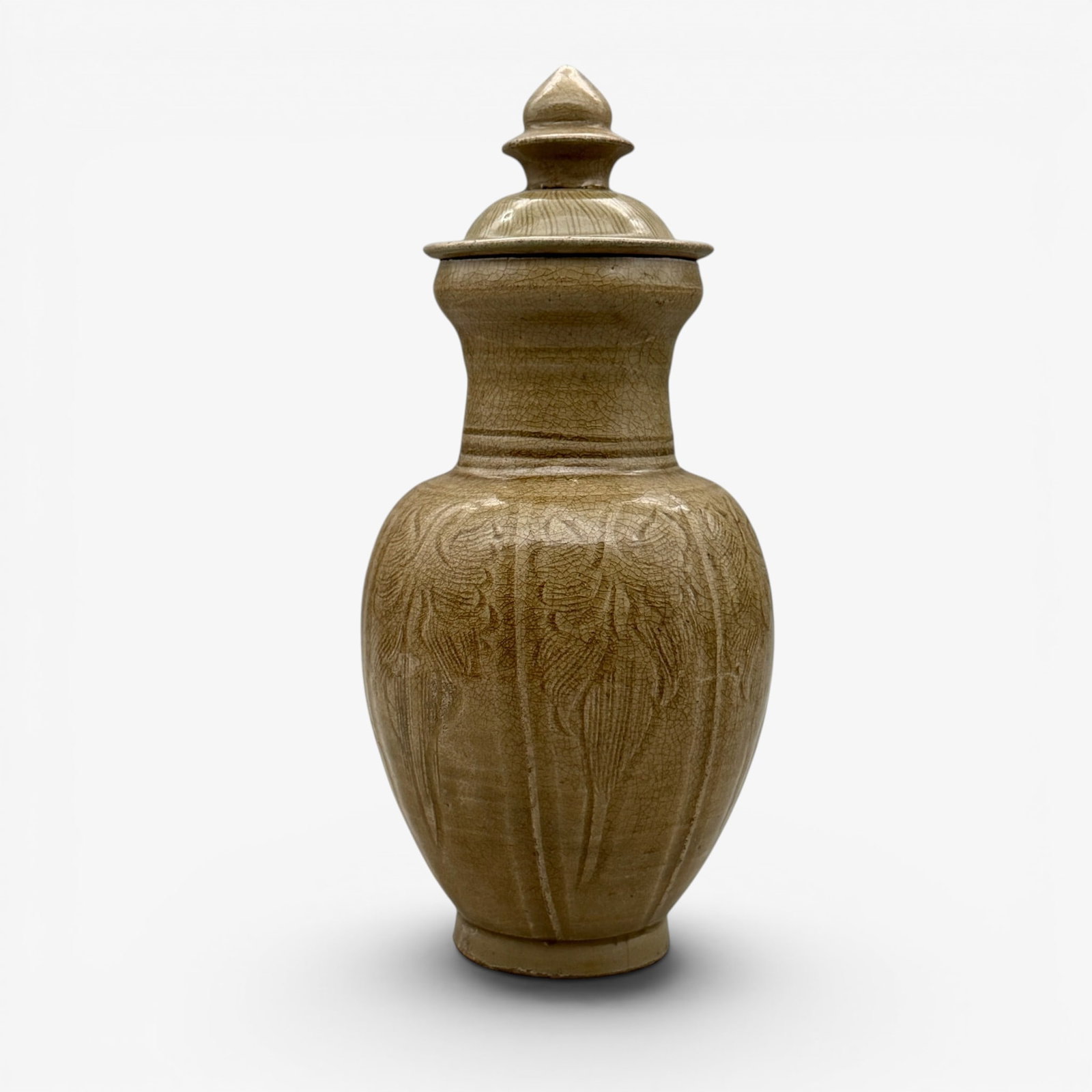 Longquan Celadon Carved Lidded Vase: Song/Yuan dynasty. Four ribs to top, carved exterior, includes lid with finial. Dark brownish glaze. Unglazed foot. Lid fits nicely. Heavily crazed. Height with lid: 11.5" PROVENANCE Private