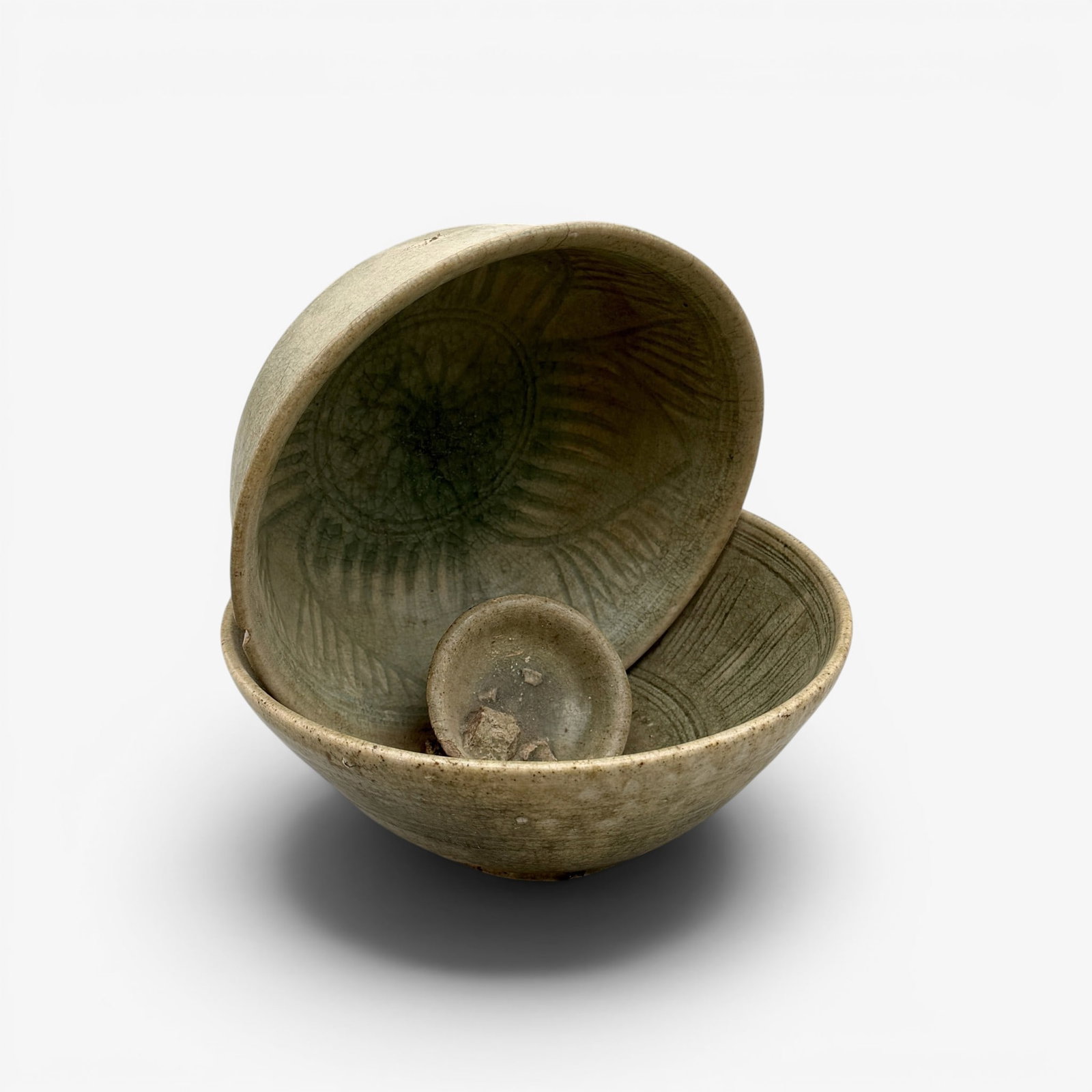 Unusual Group of Longquan Bowls Fused Together: Song/Yuan dynasty, a group of two larger and one small longquan celadon bowls, fused together either from the kiln or a shipwreck, the two larger bowls with incised interiors. Ht. 8.25".