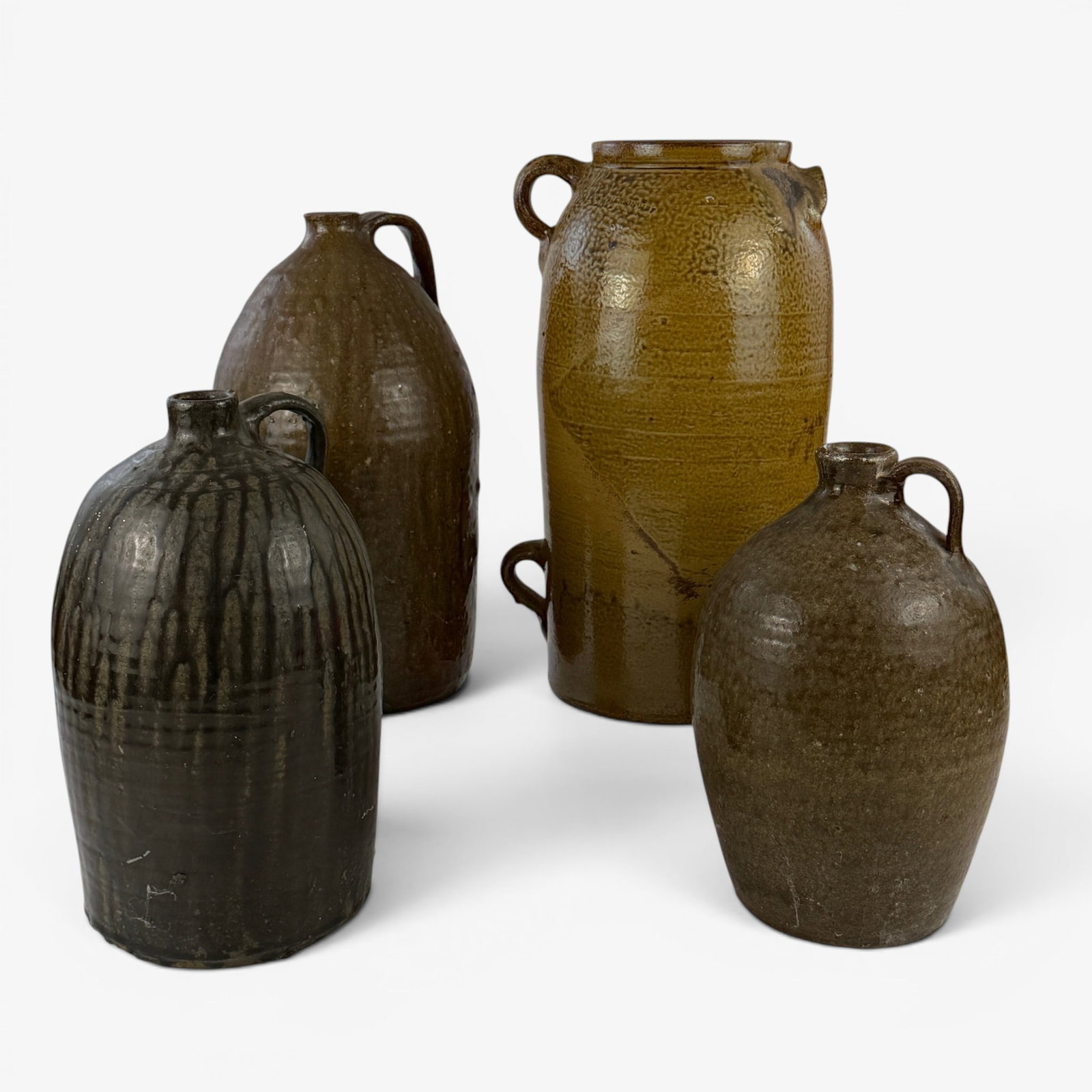 Four Southern Alkaline Stoneware Jugs, Incl. McPherson: Four stoneware jugs in alkaline glaze, including the tallest marked "McPherson" for Alabama. Tallest ht. 16.5".